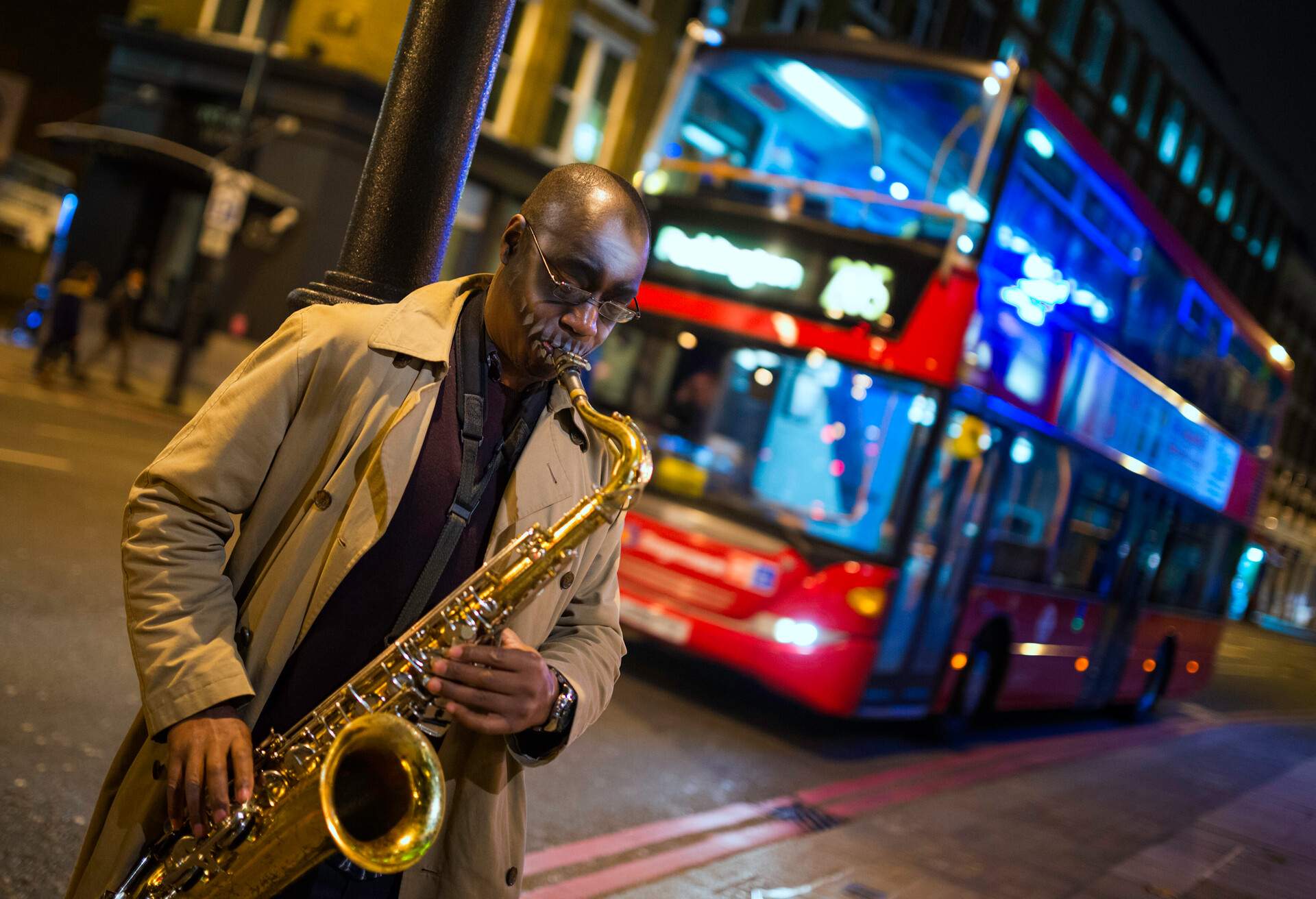 Black Street Musician in London, UK, playing on saxophone in the evening,