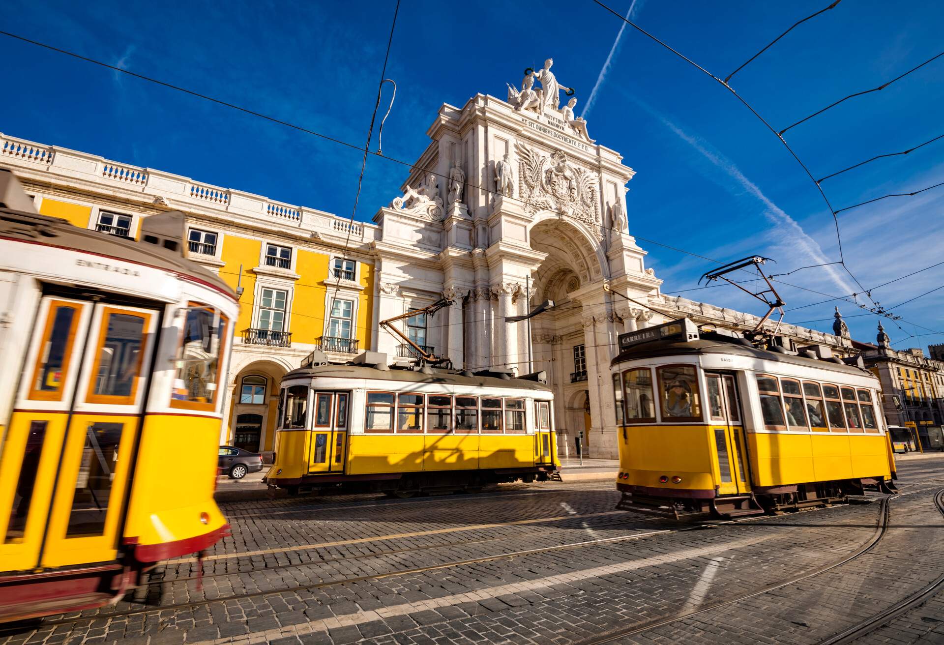 Lisbon's traditional trams in front of Arco da Rua Augusta (Rua Augusta Arch) - Lisbon, Portugal