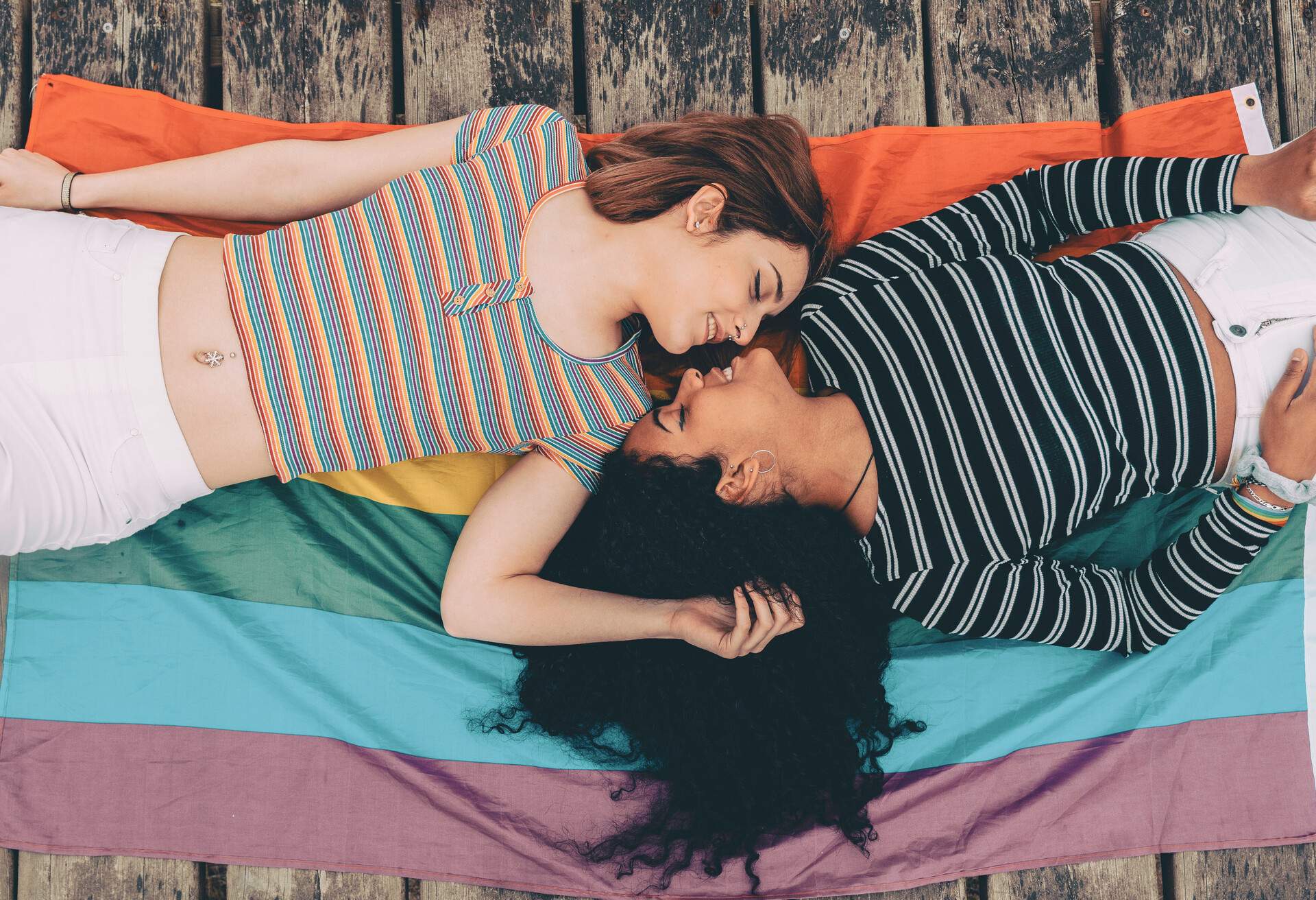 Cute lesbian couple lying together on the carpet - Image