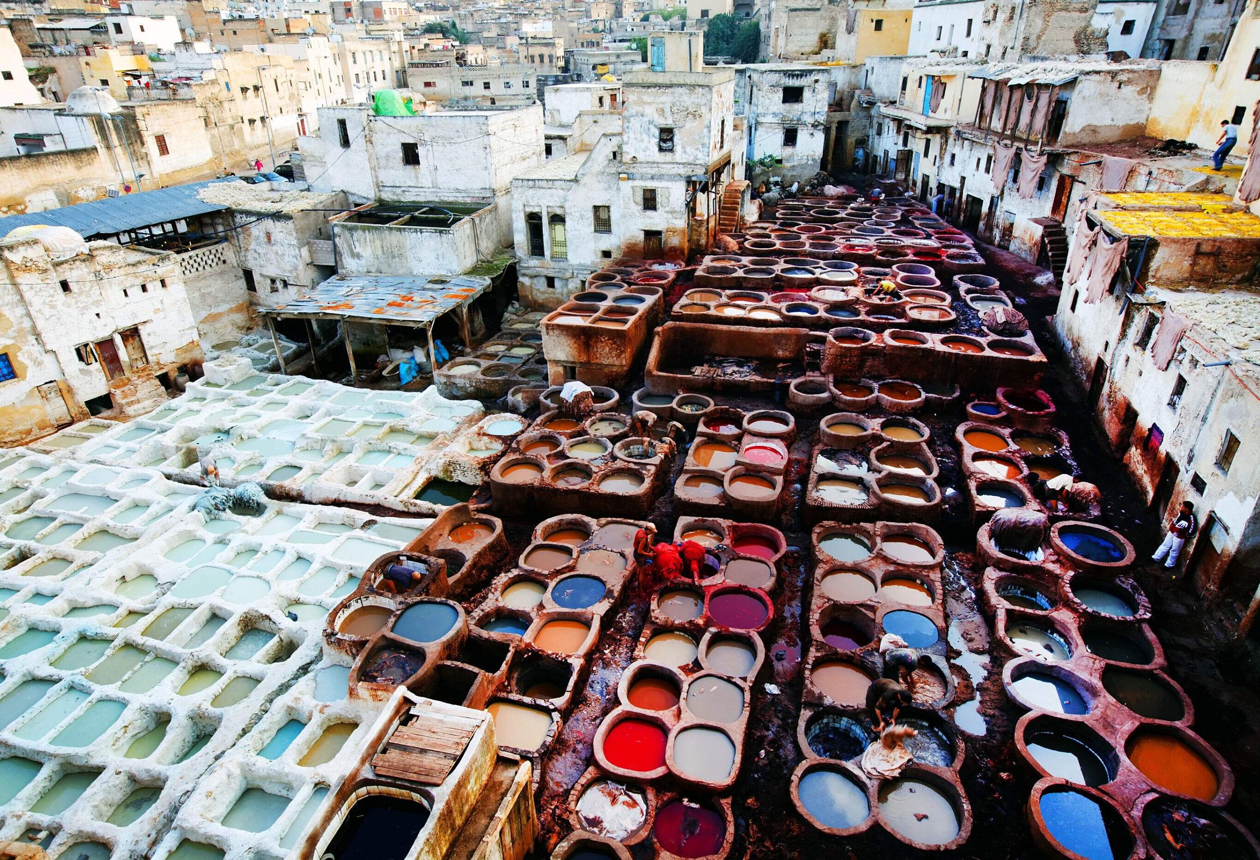 A collection of adjacent containers with colourful varieties of dye.