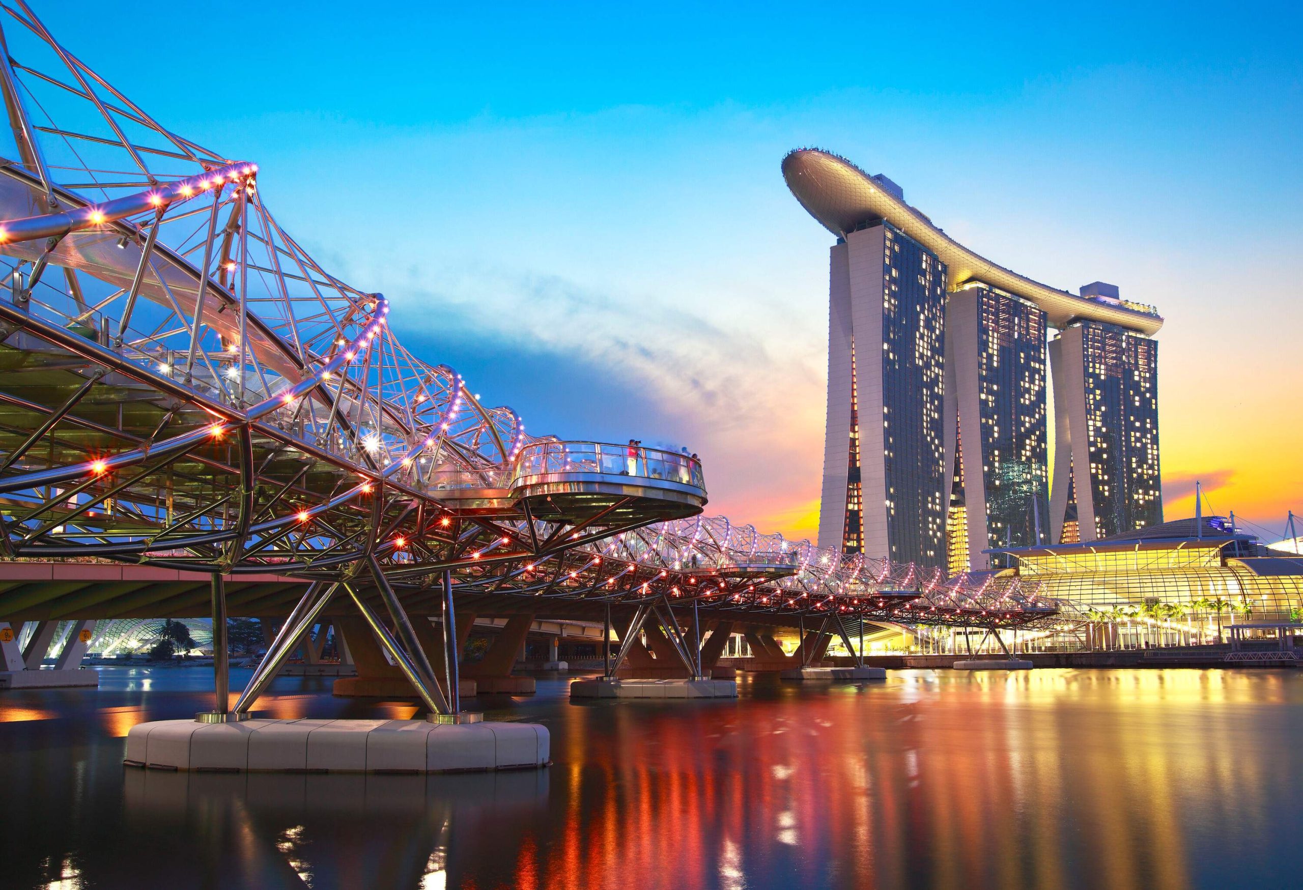 A steel footbridge over the bay inspired by the curved form of the structure of DNA and the brightly lit Marina Bay.
