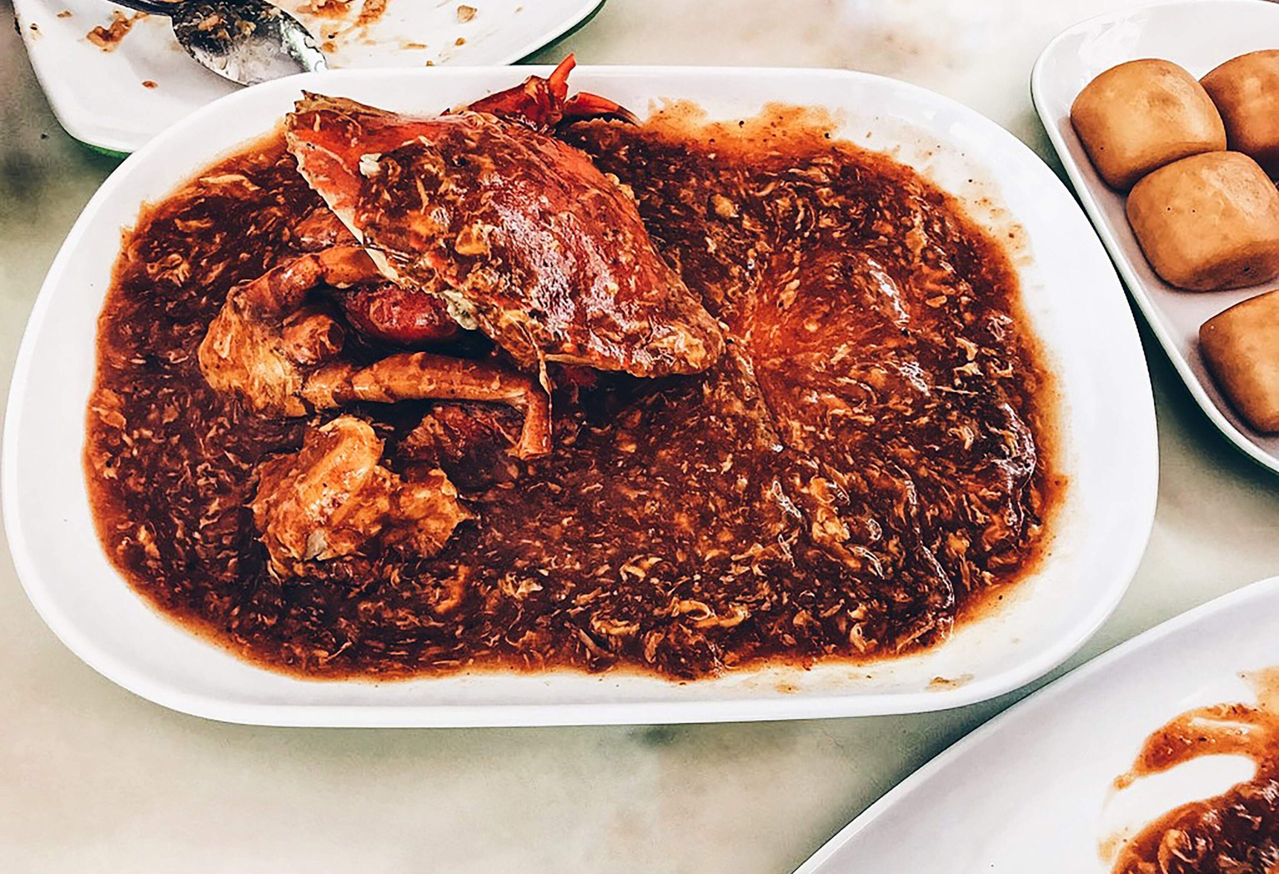 A plate of crab dish glazed with red chili sauce.
