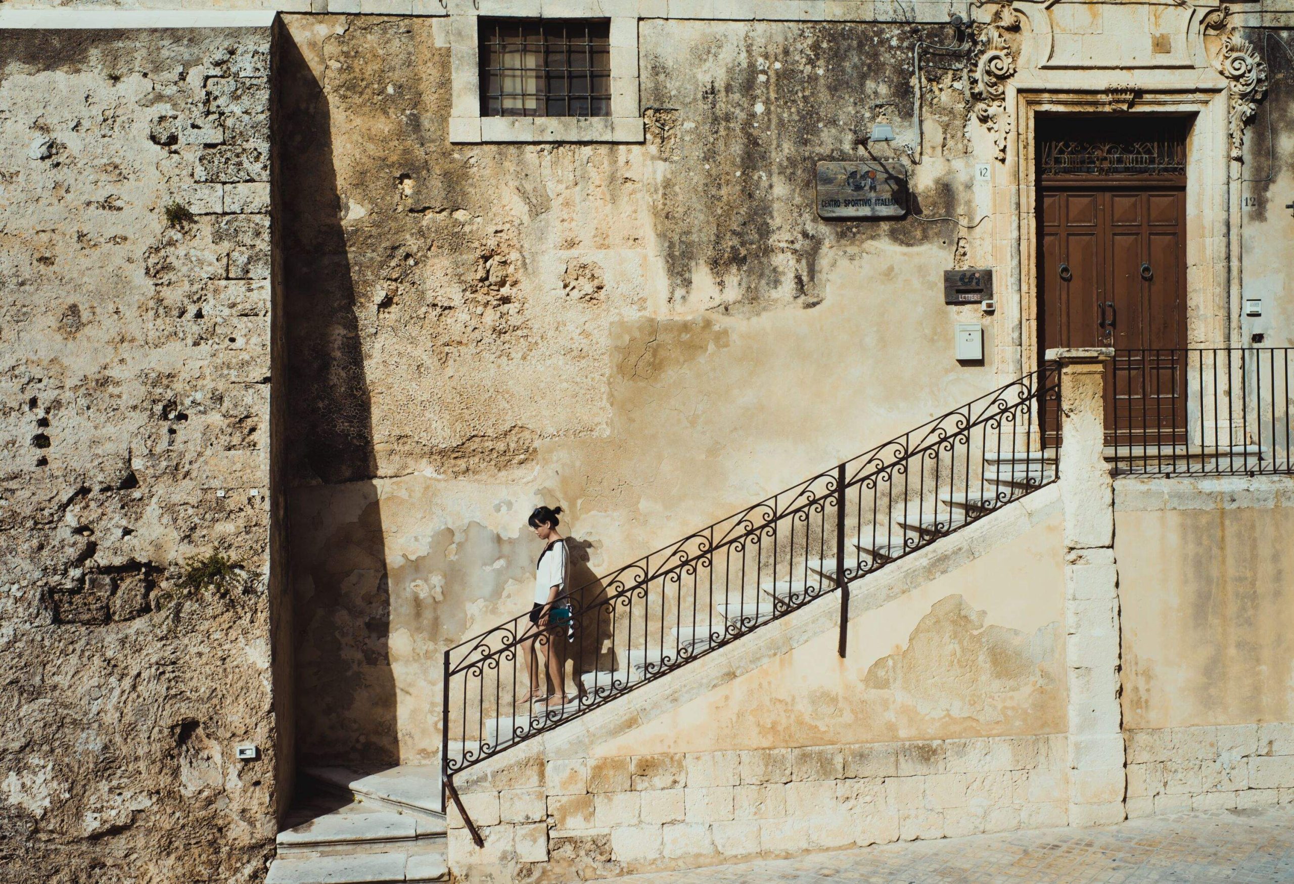 GIRL DESCENDING STAIRS OF OLD BUILDING