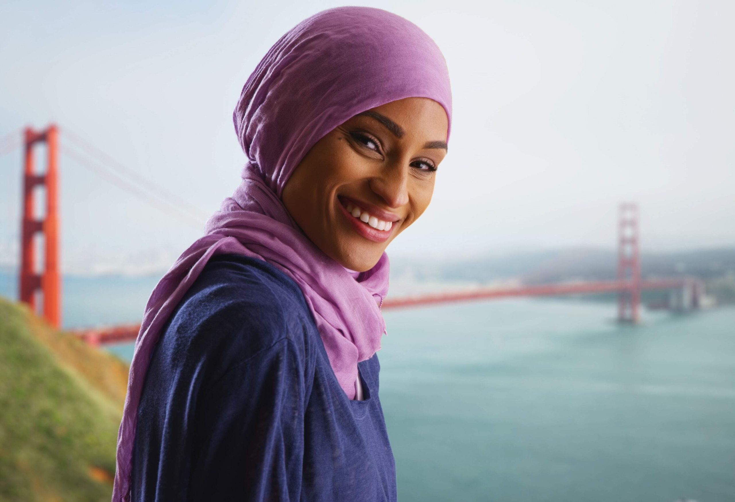 A beautiful woman in hijab against the Golden Gate Bridge in San Francisco, California.