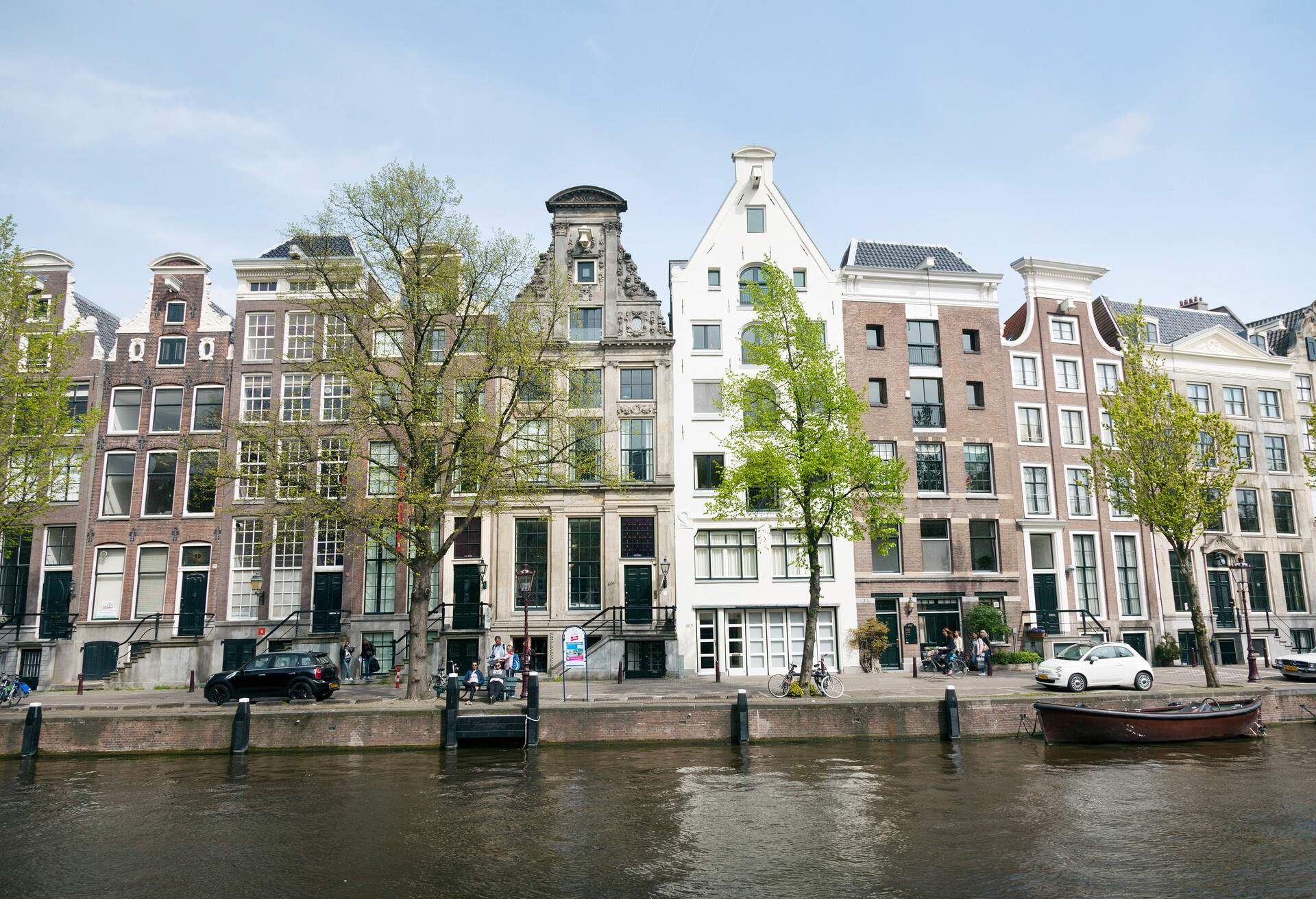 A row of traditional dutch buildings by the canal in Amsterdam on a spring day 