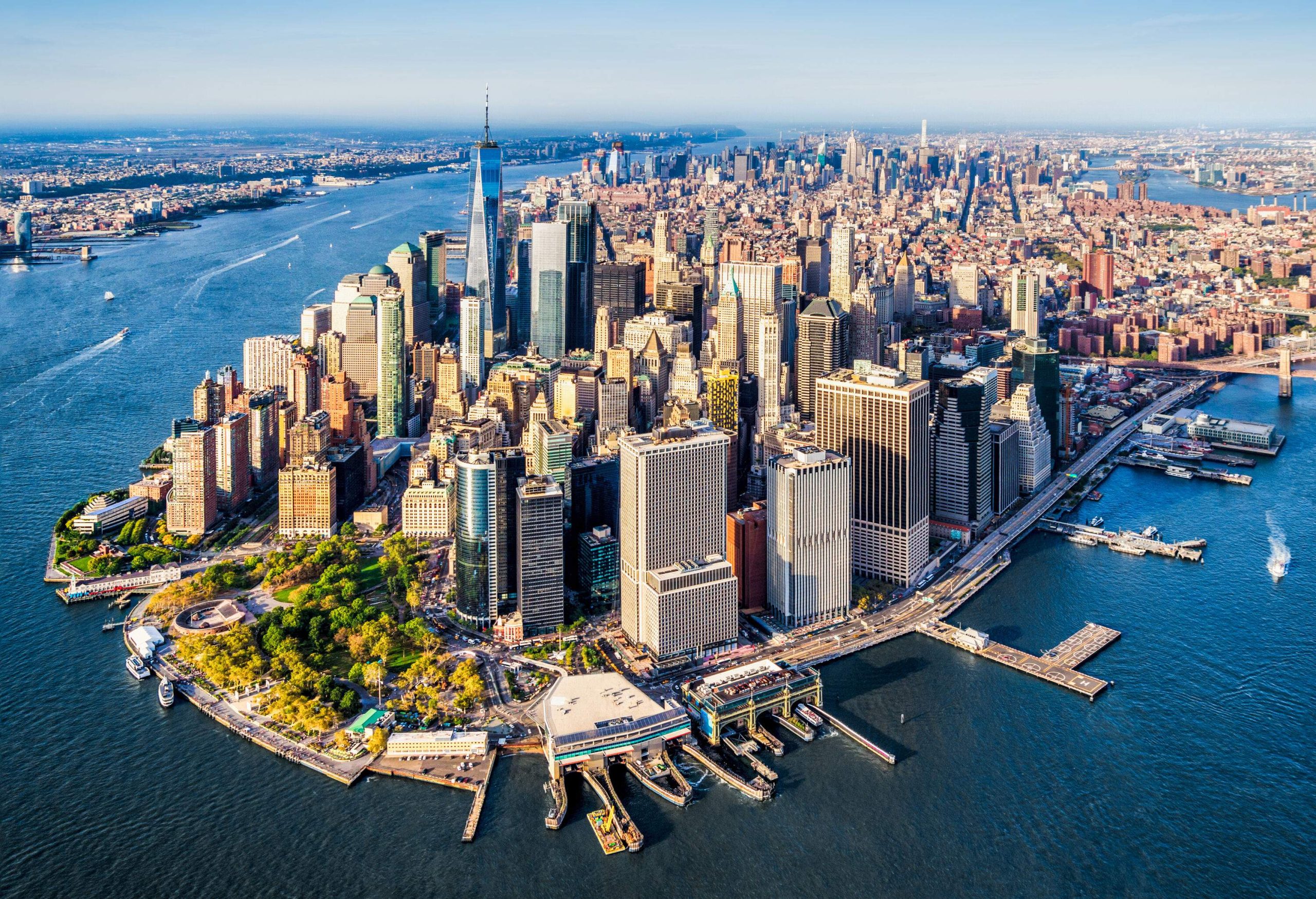 Lower Manhattan, the vibrant financial district of New York City, is surrounded by the glistening waters of the Hudson River and the East River, with its iconic skyscrapers and bustling streets.