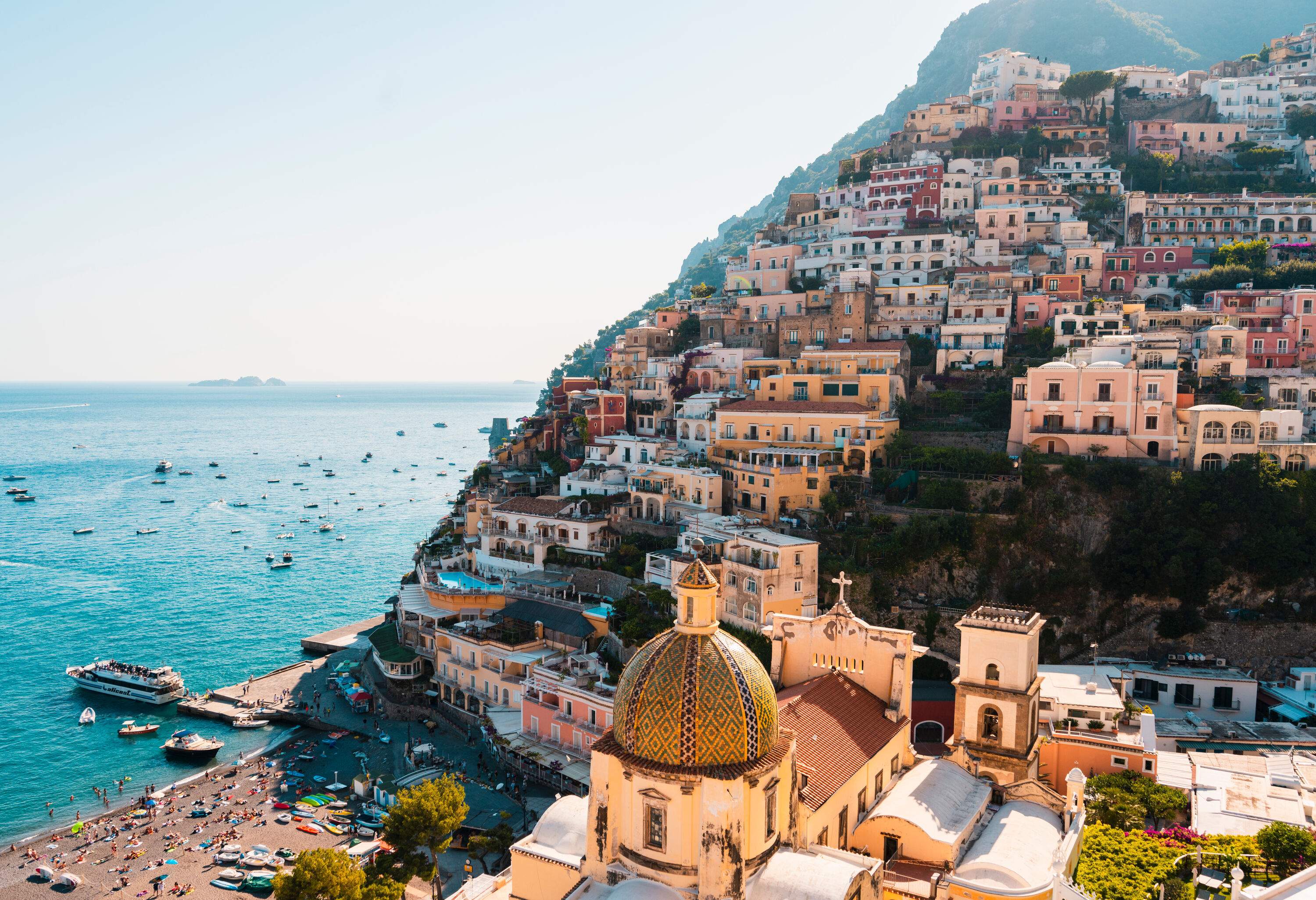 Positano's colourful cityscape with leisure and fishing boats on the sea