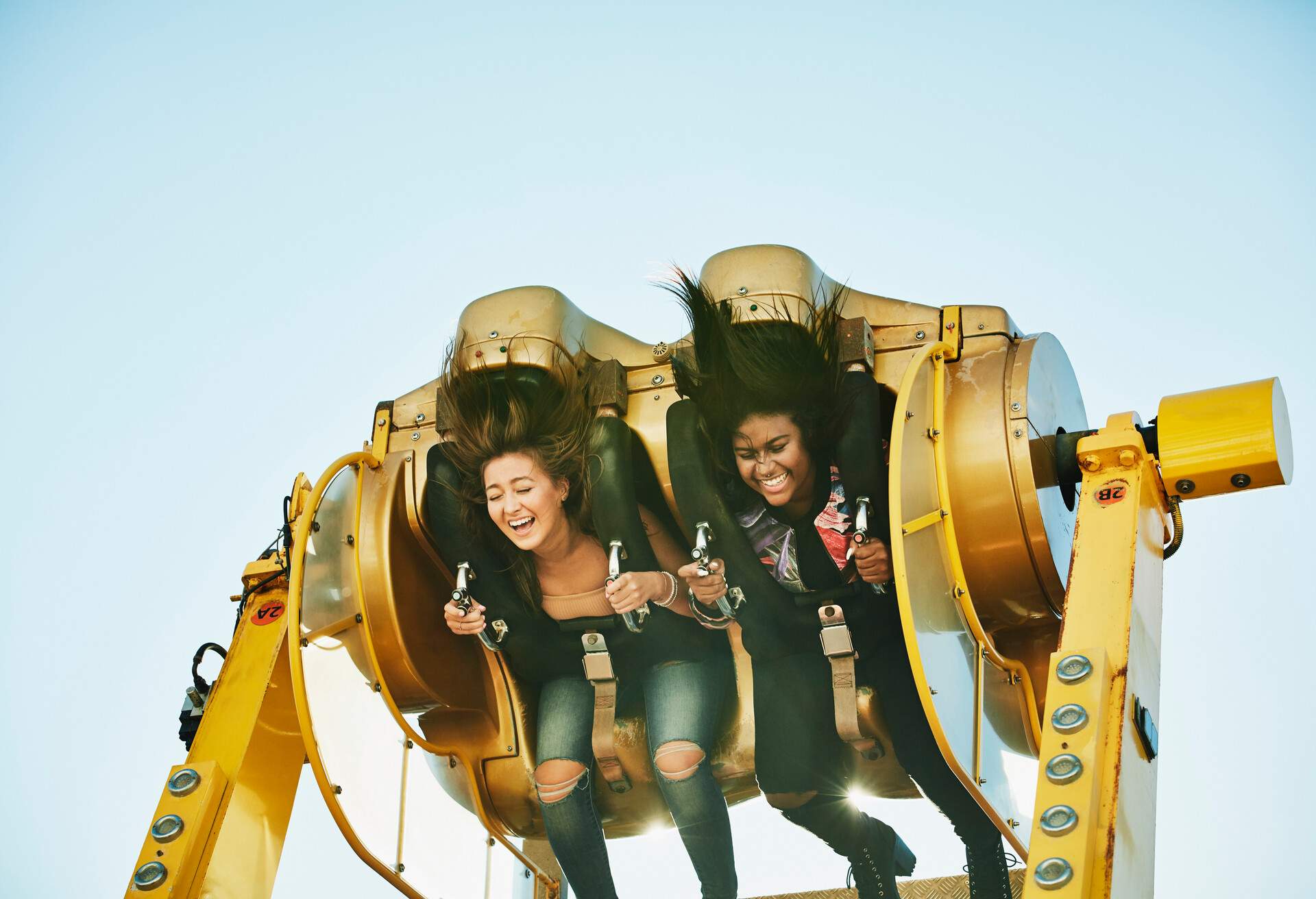 Two women going on a wild ride at an amusement park.