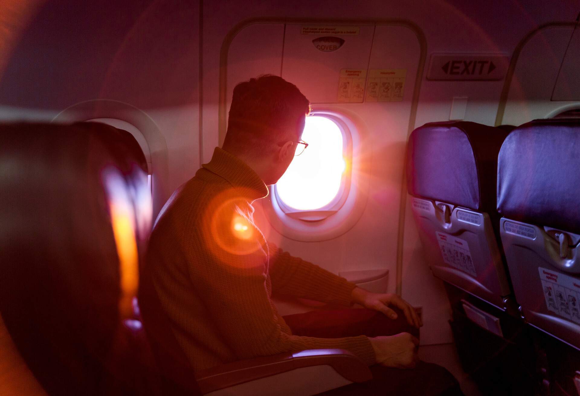 A man on a plane looking through a window