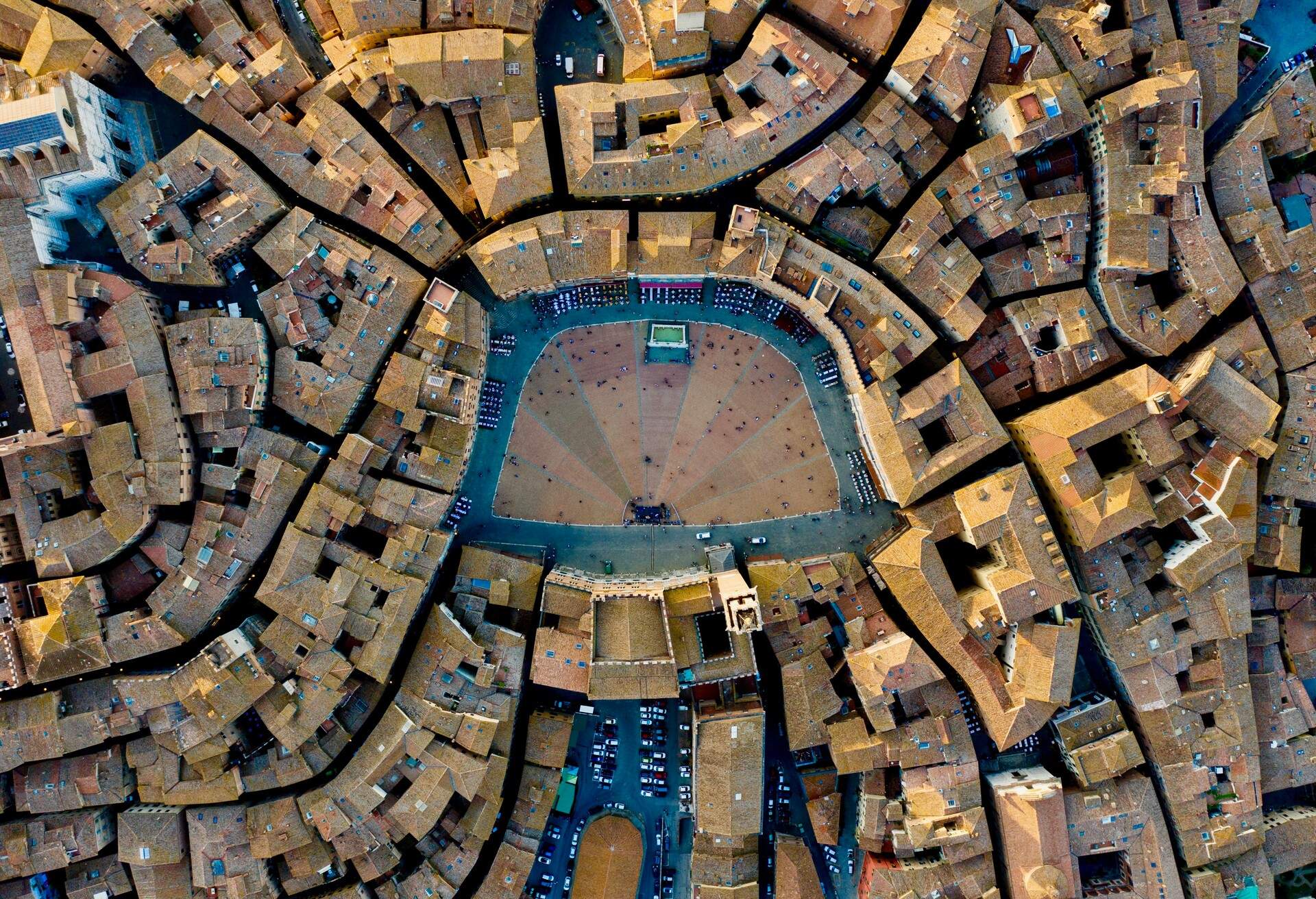 A medieval shell-shaped town square in the middle of compact buildings.