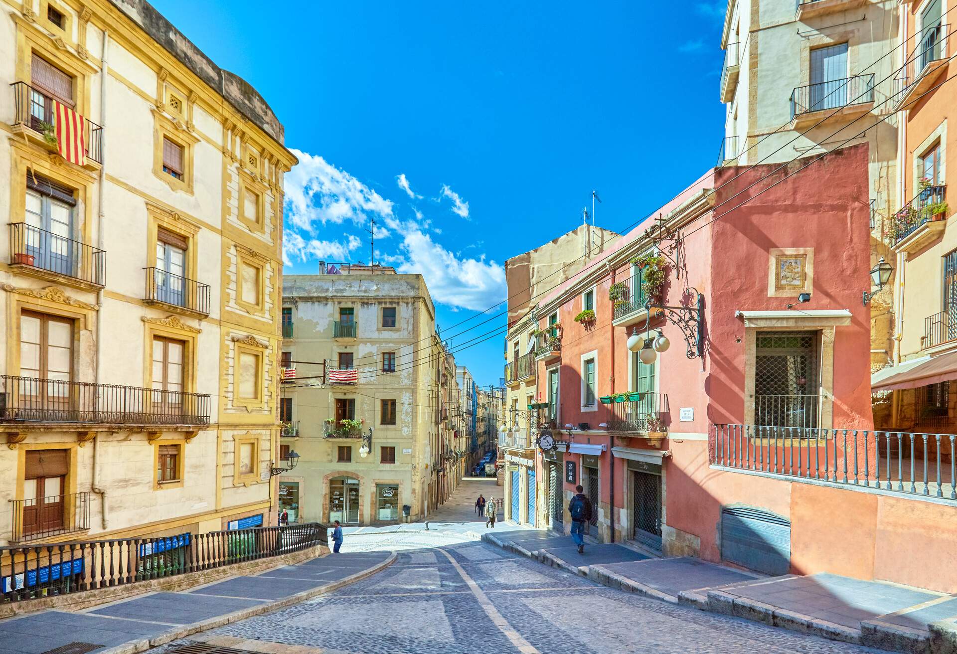 A sloping street surrounded by neighbourhood buildings.