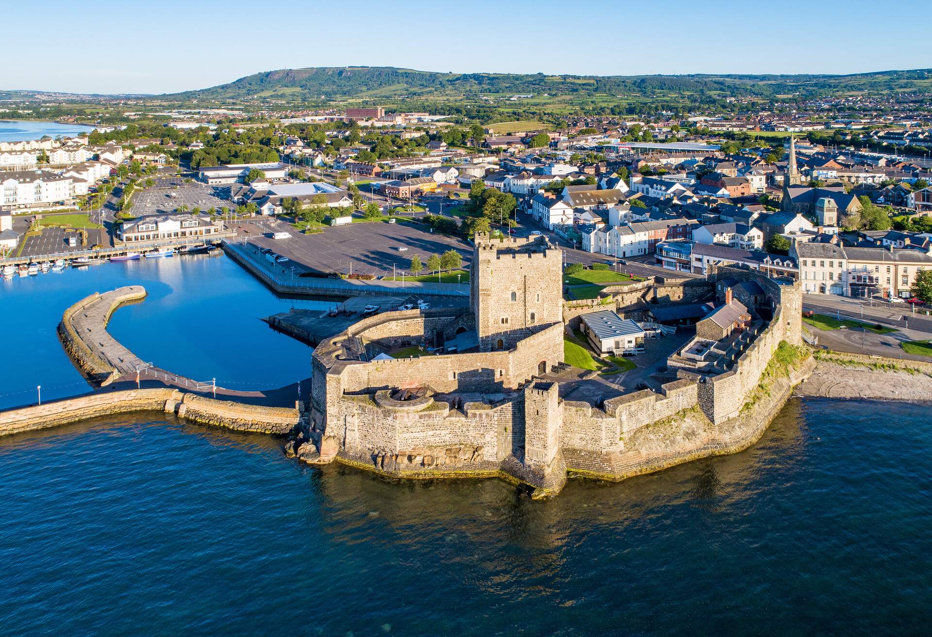 A medieval fortified castle overlooking a harbour entrance and inland villages.
