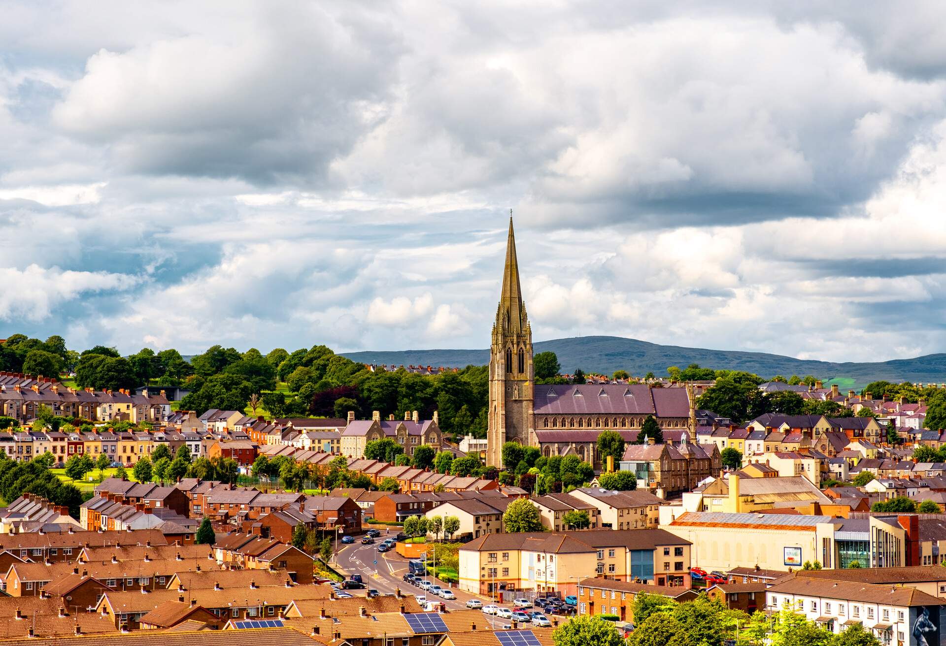 A Gothic-style steeple towering over the city structures and houses.