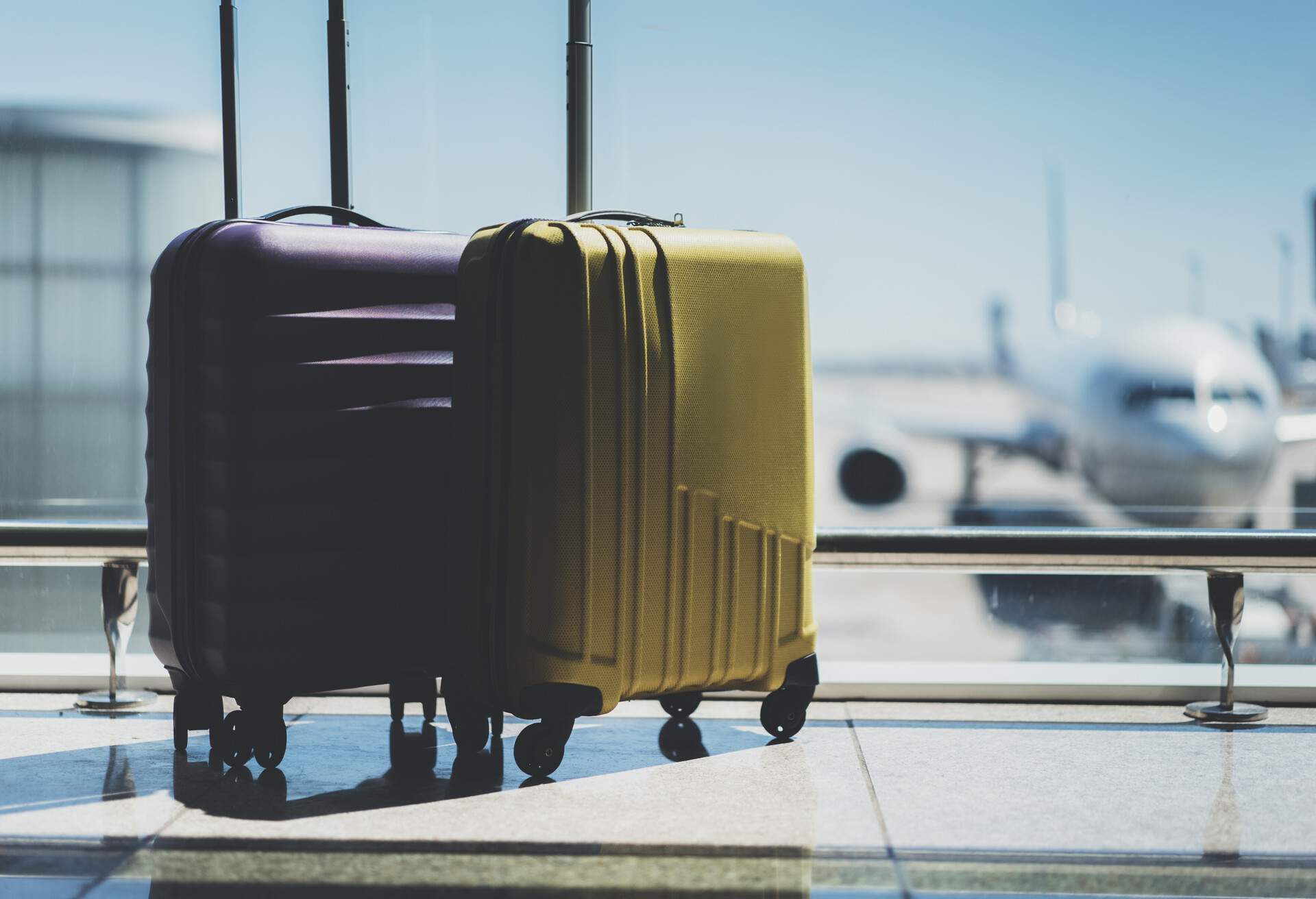 Portrait of two spinner luggage in an airport lounge.