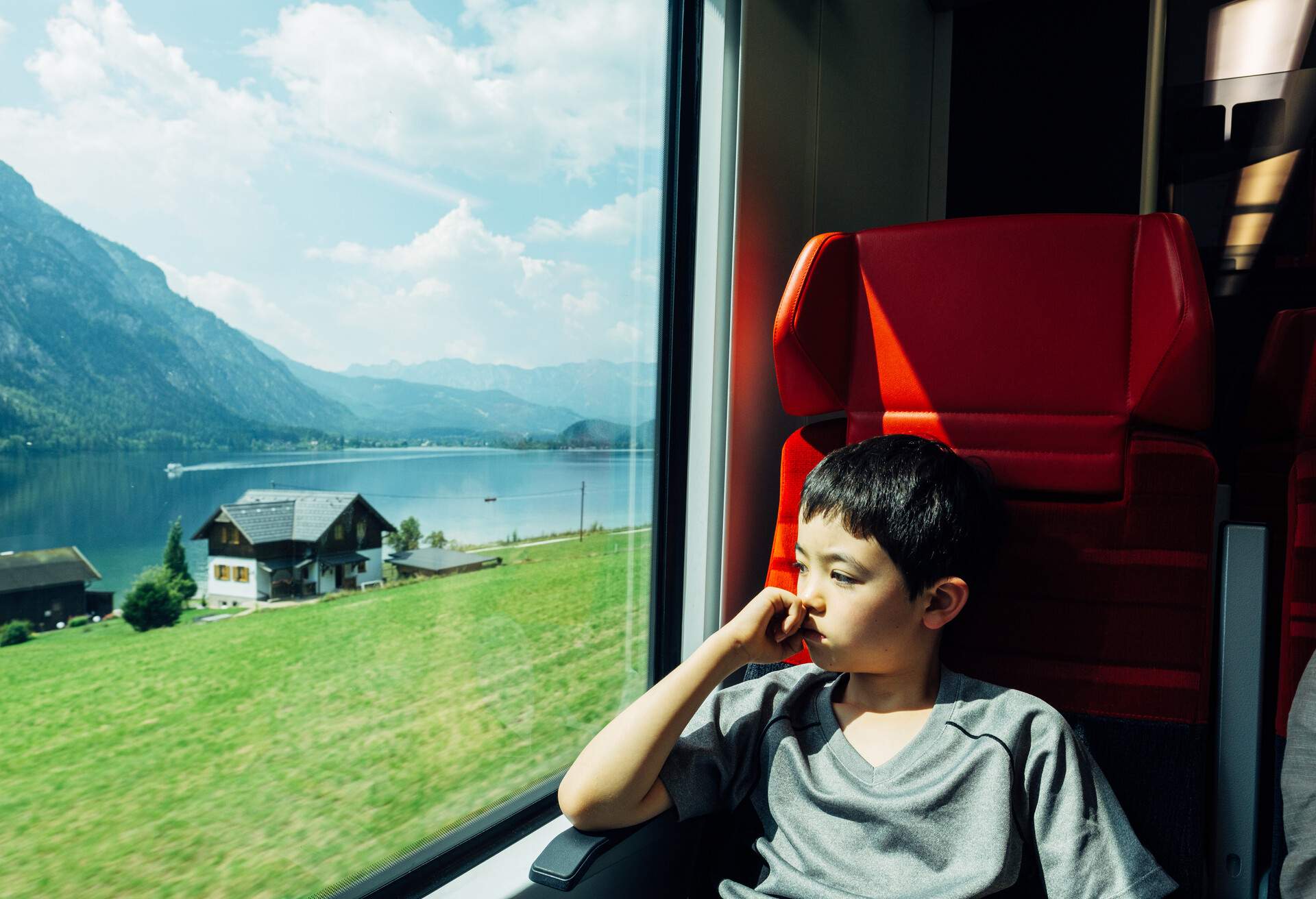 A young boy looking out of the window on a train in Austria travelling to Hallstatt from Vienna.