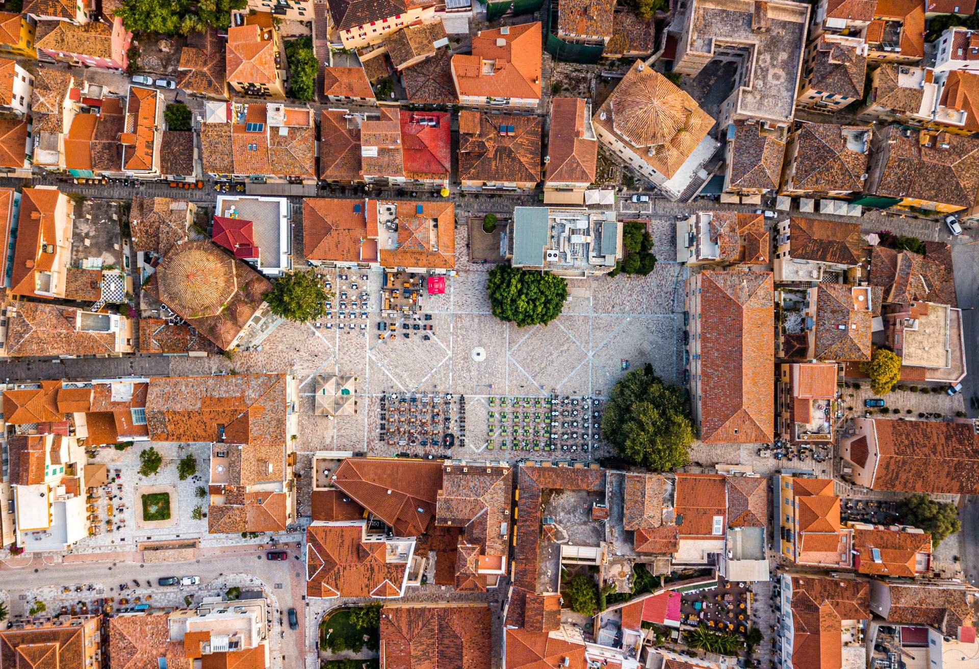 This is an aerial drone photo of the central square of the Greek town of Nafplio. The square is called Syntagme (Constitution). Being the first capital and having large of the modern Greek state (before Athens) it is visited by tourists all year long.