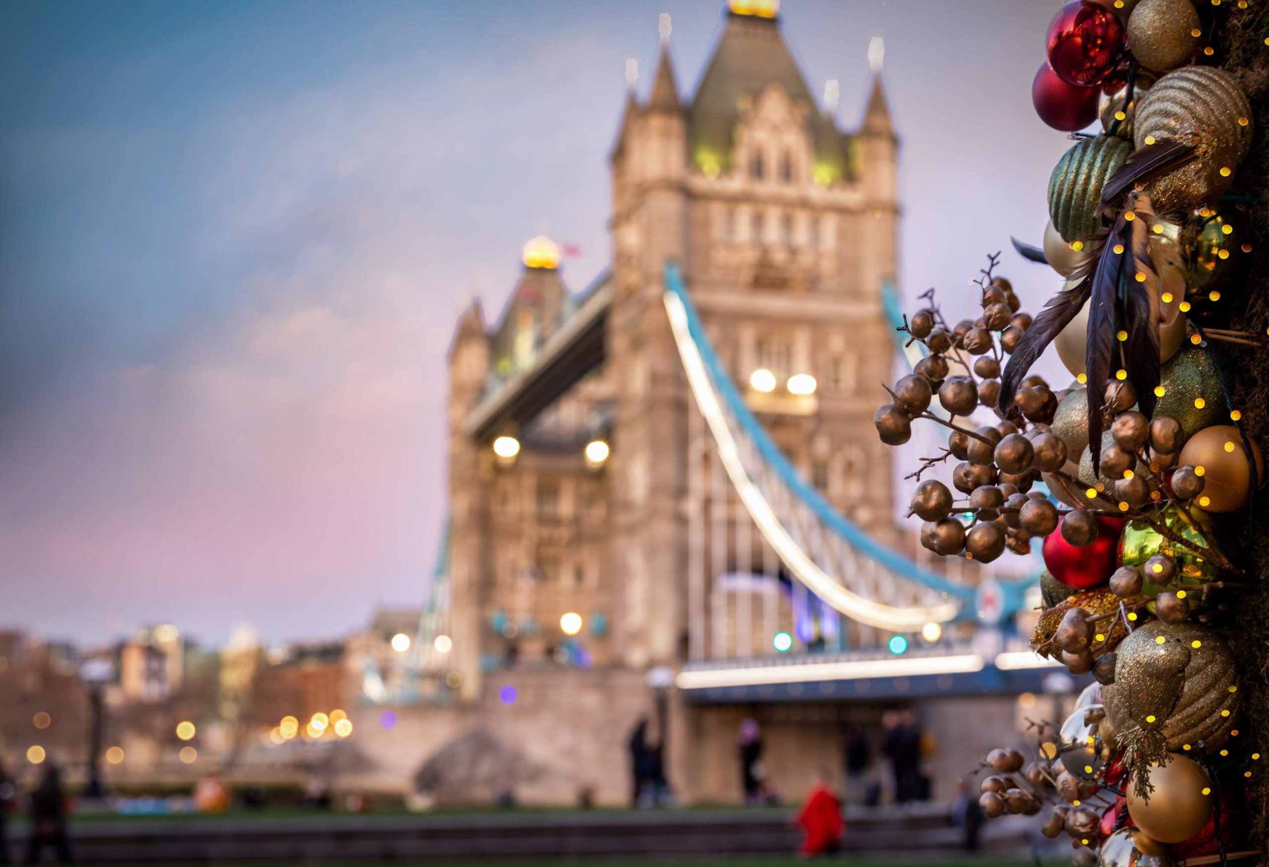 View to the illuminated Tower Bridge in London, United Kingdom, with christmas decorations in front for the festive season