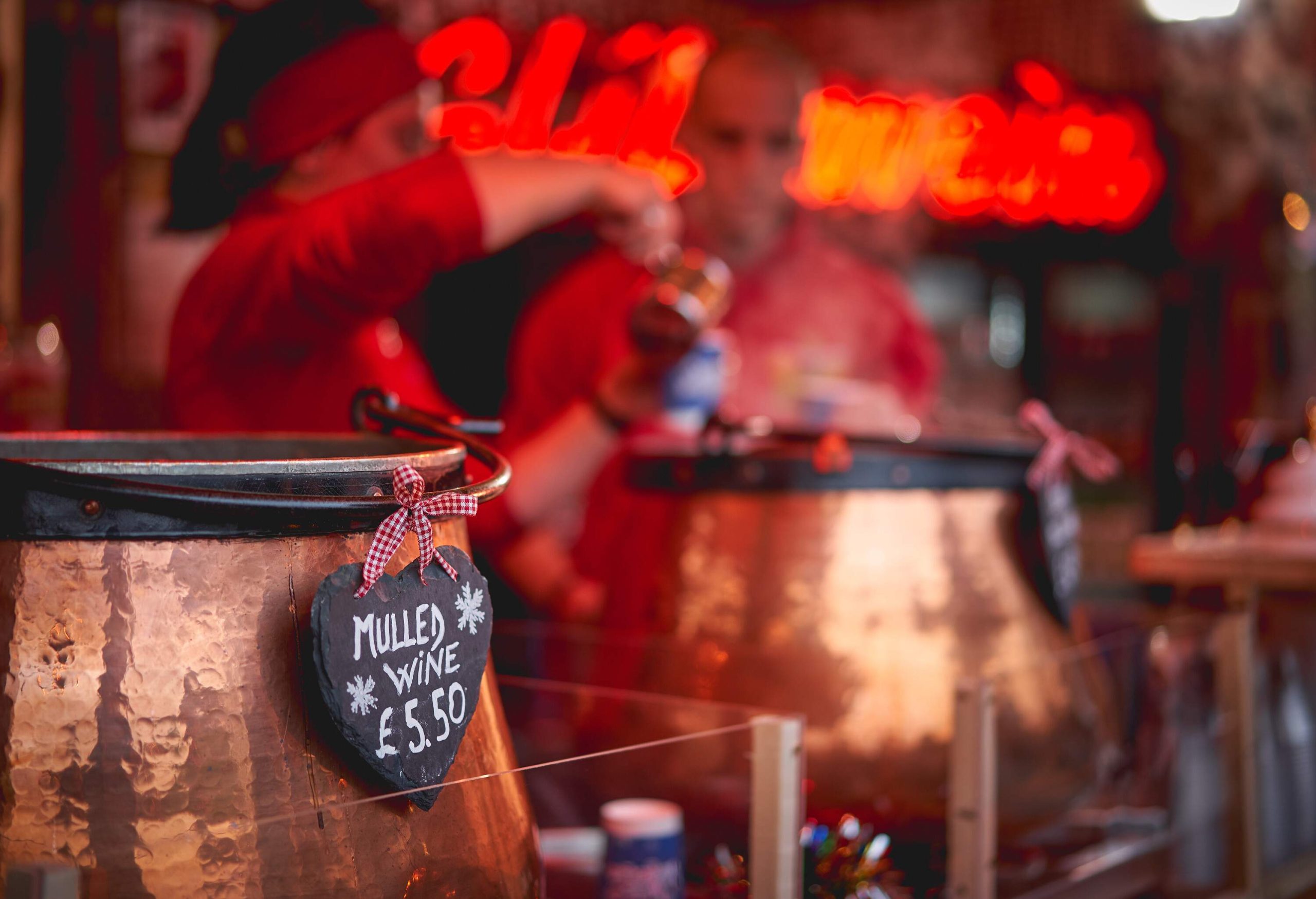 Pots of mulled wine in a stall in a Christmas market.