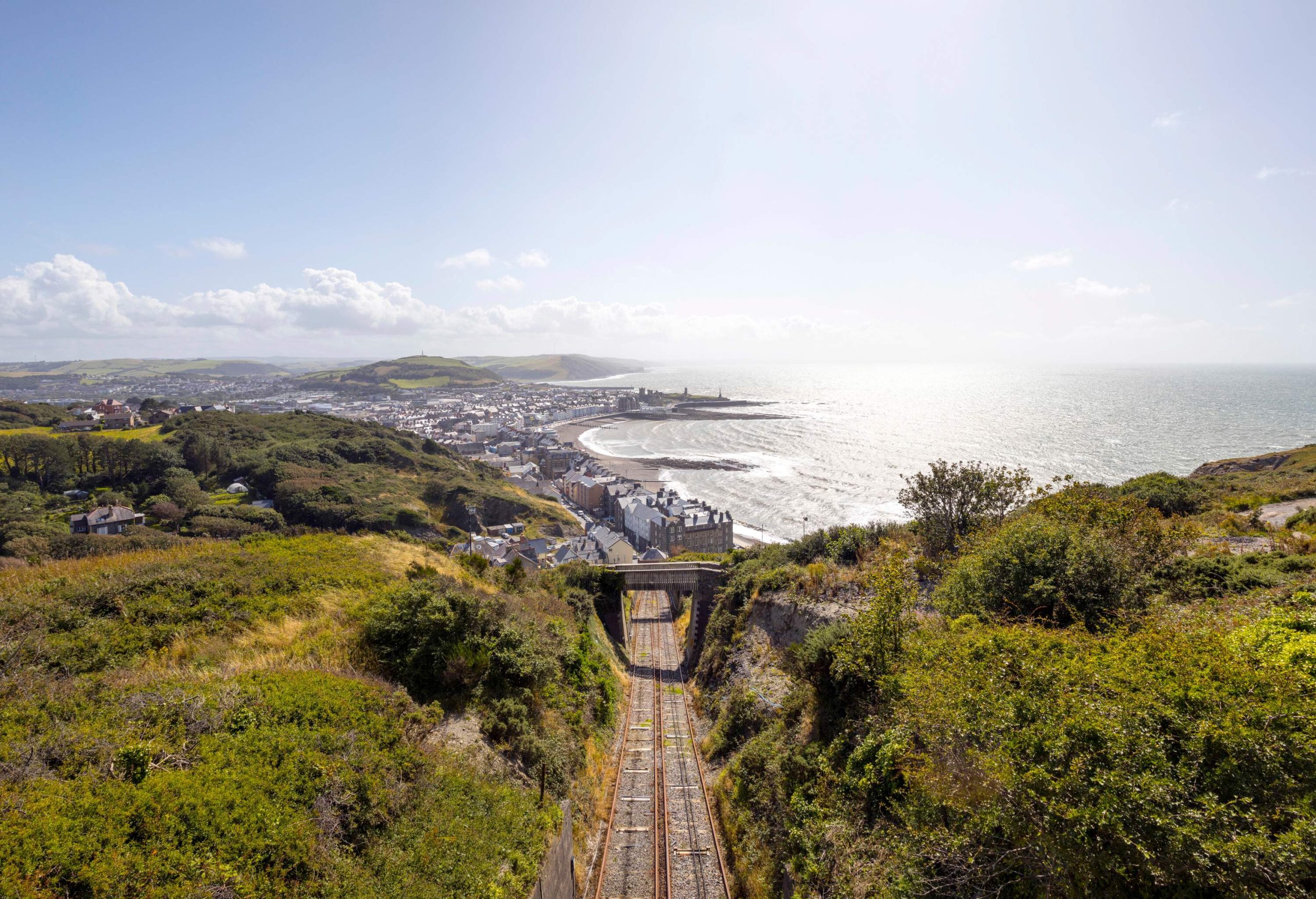 View over Aberystwyth town and Ceredigion coastline with Aberystwyth Cliff Railway tracks - the longest fenicular railway in Great Britain. Taken from top of Constitution Hill, Aberystwyth, Mid Wales, Britain.