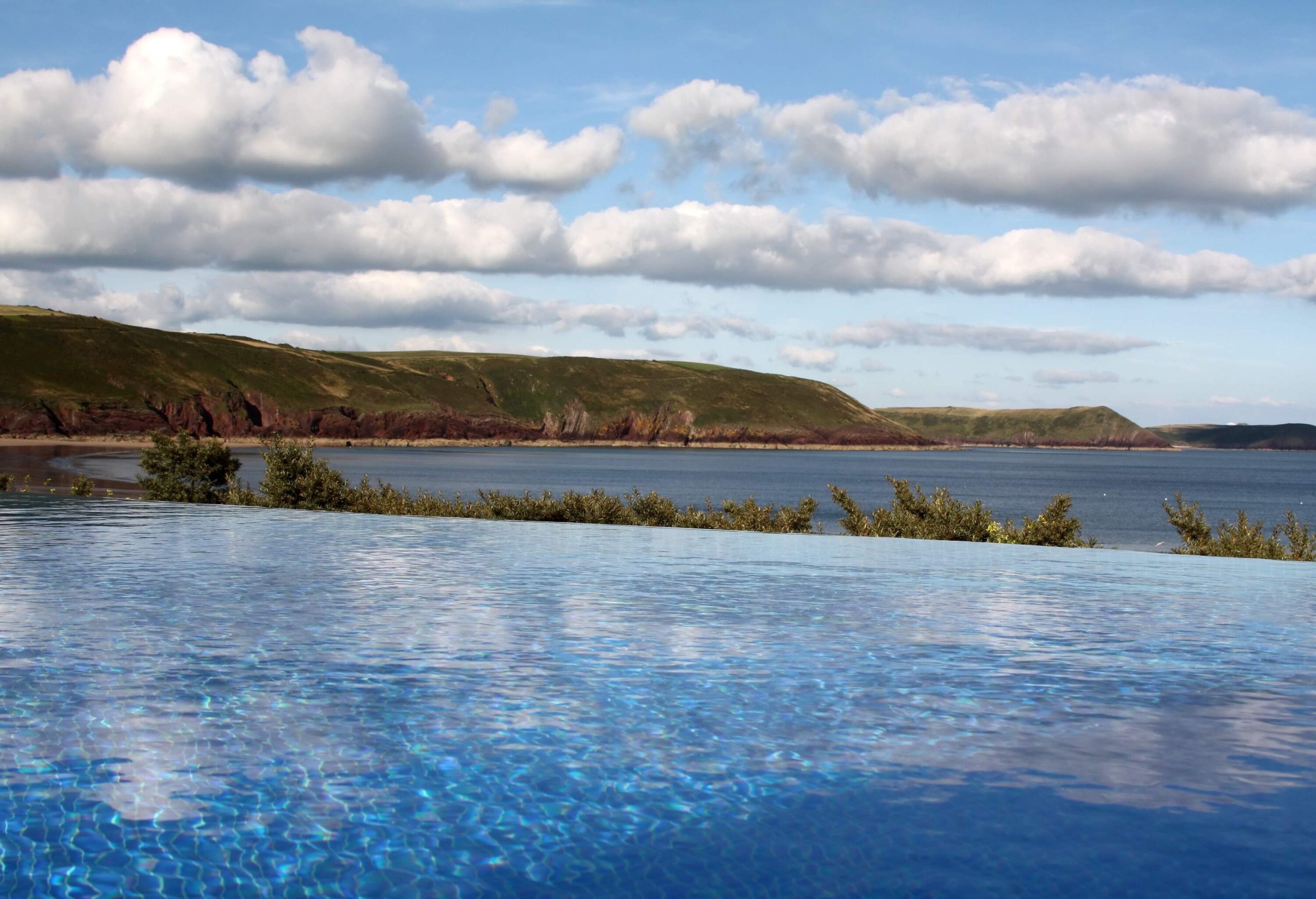 Infinity swimming pool at holiday cottage, looking out onto freshwater Beach, Pembrokeshire coastline, Wales.