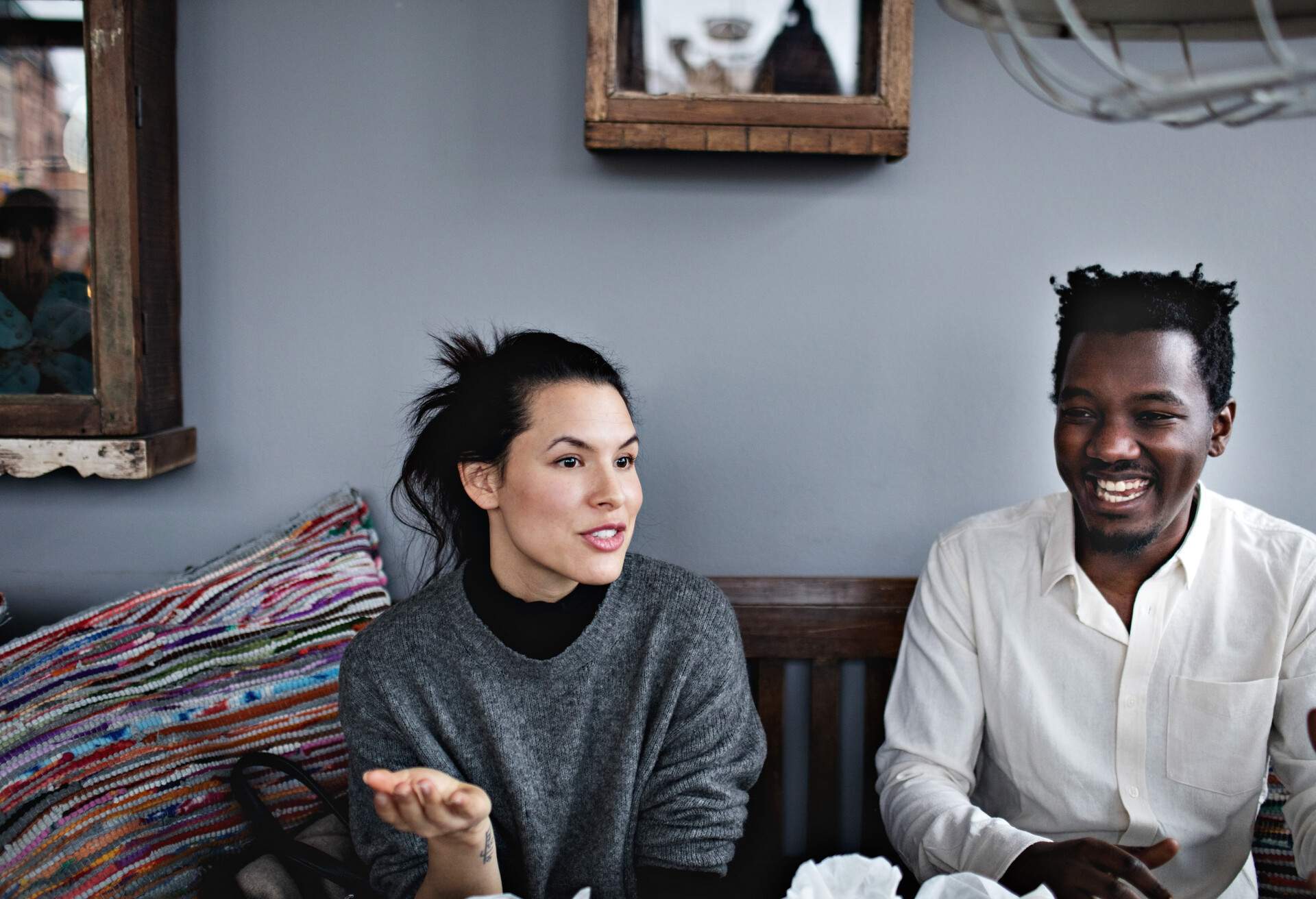 Two individuals converse while sitting in a restaurant.