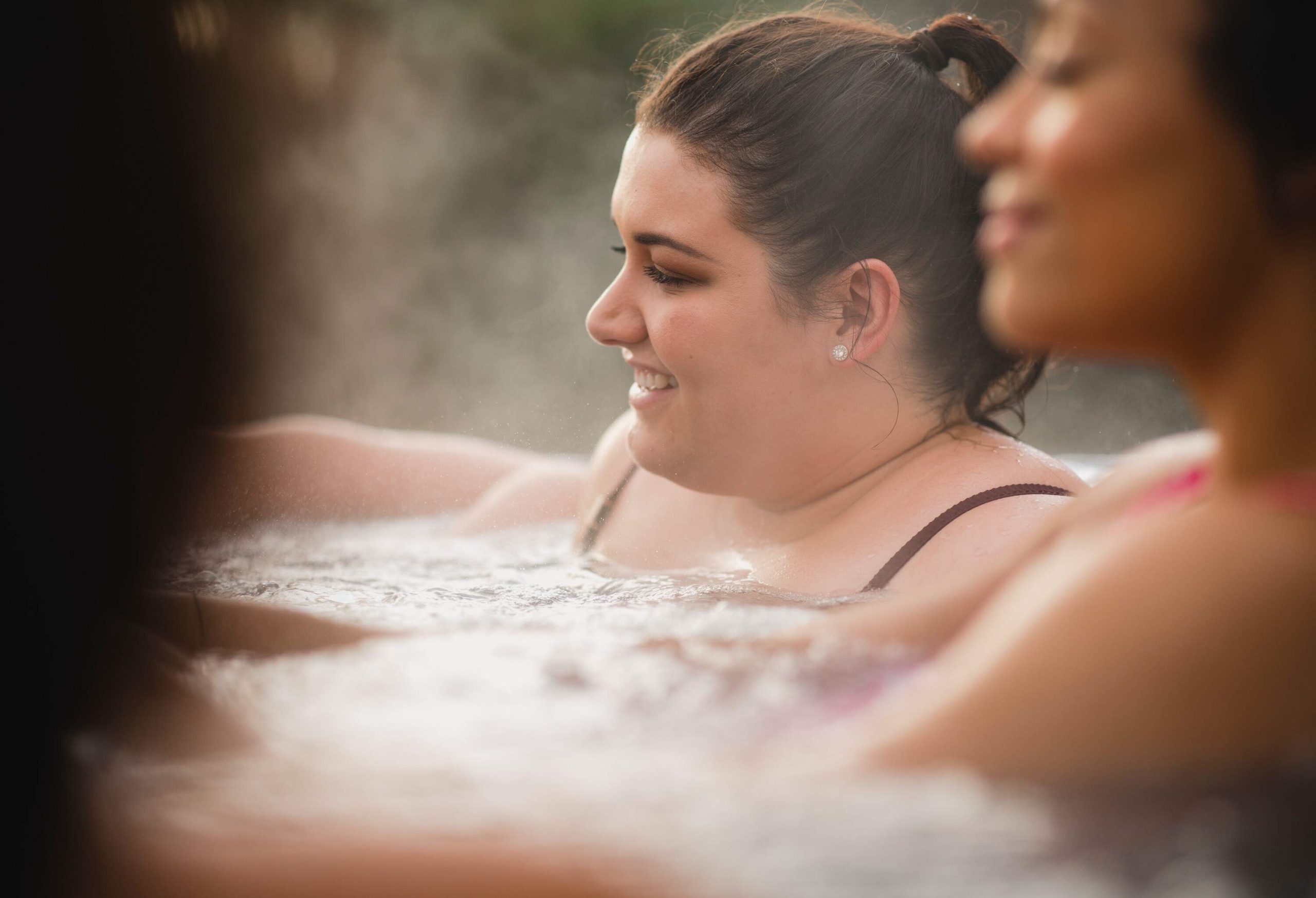 Mid adult woman relaxing in a hot tub with her friends.