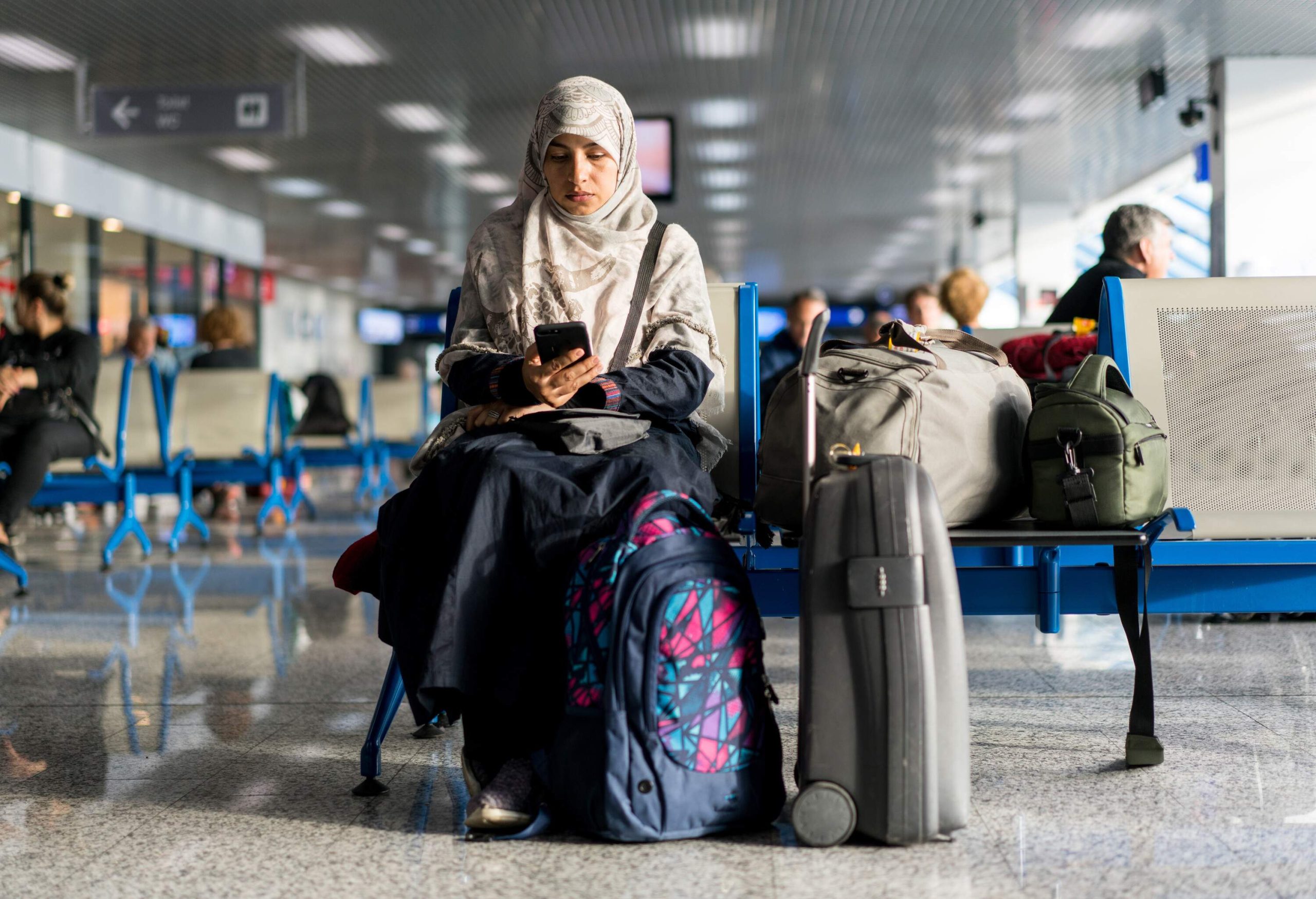 Muslim woman wearing traditional clothes sitting and waiting for her airplane flight.