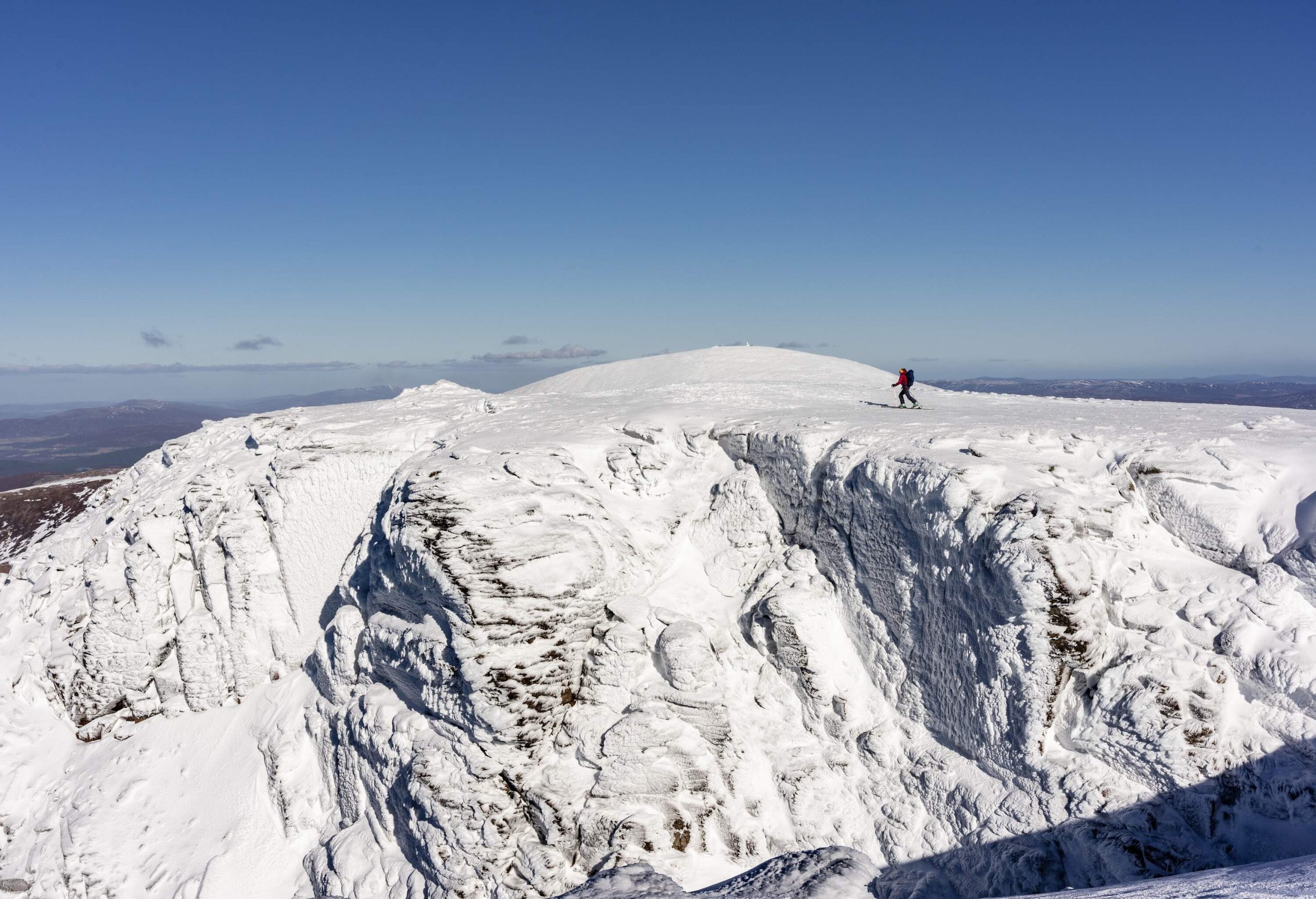 Panoramic view on snow covered mountains and skier on a sunny day, Scotland UK