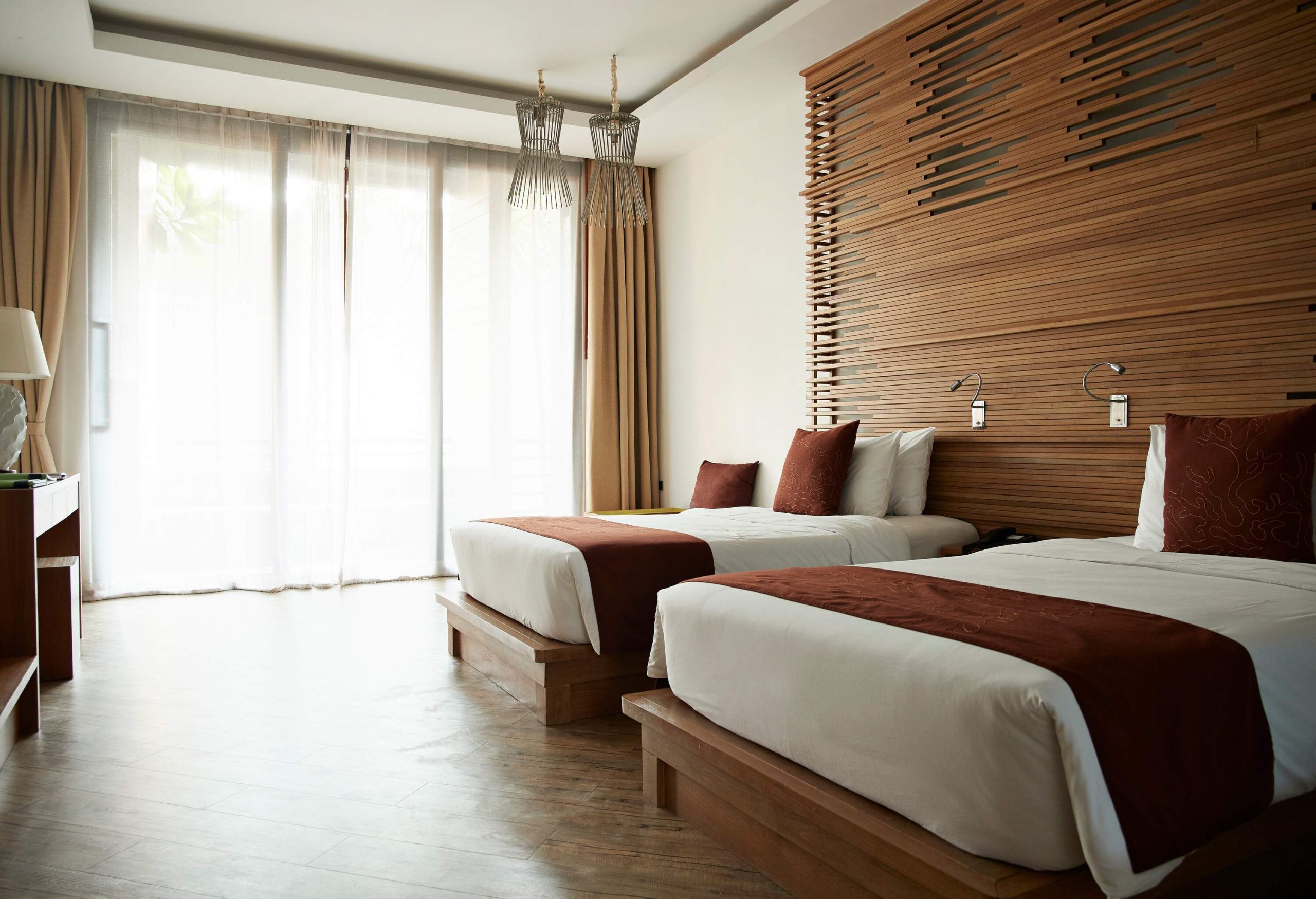 Two cosy beds inside a hotel bedroom.