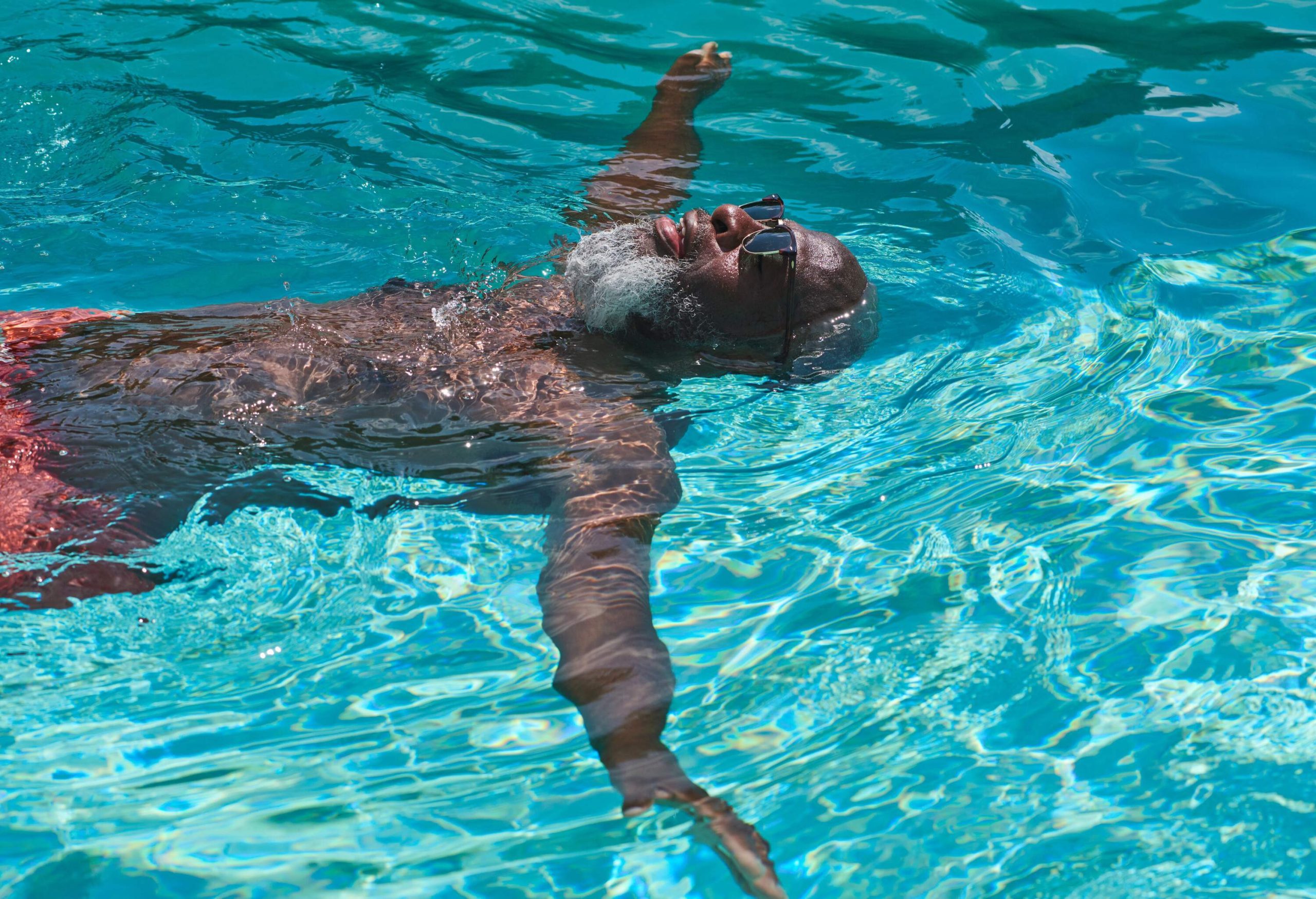 dest_spain_ibiza_hotel_pool_man_relaxes_gettyimages-1192125536