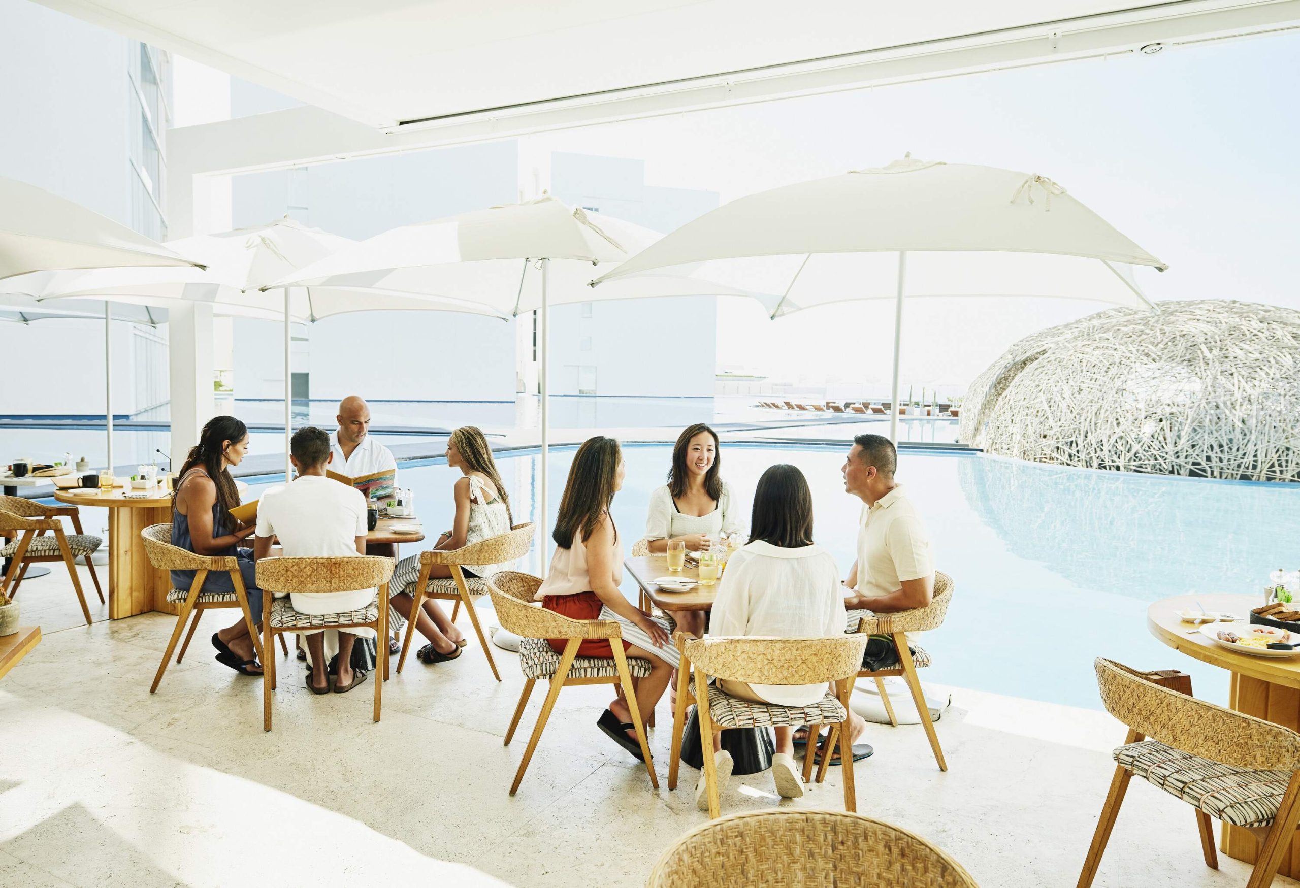 Families having lunch or breakfast at a poolside restaurant