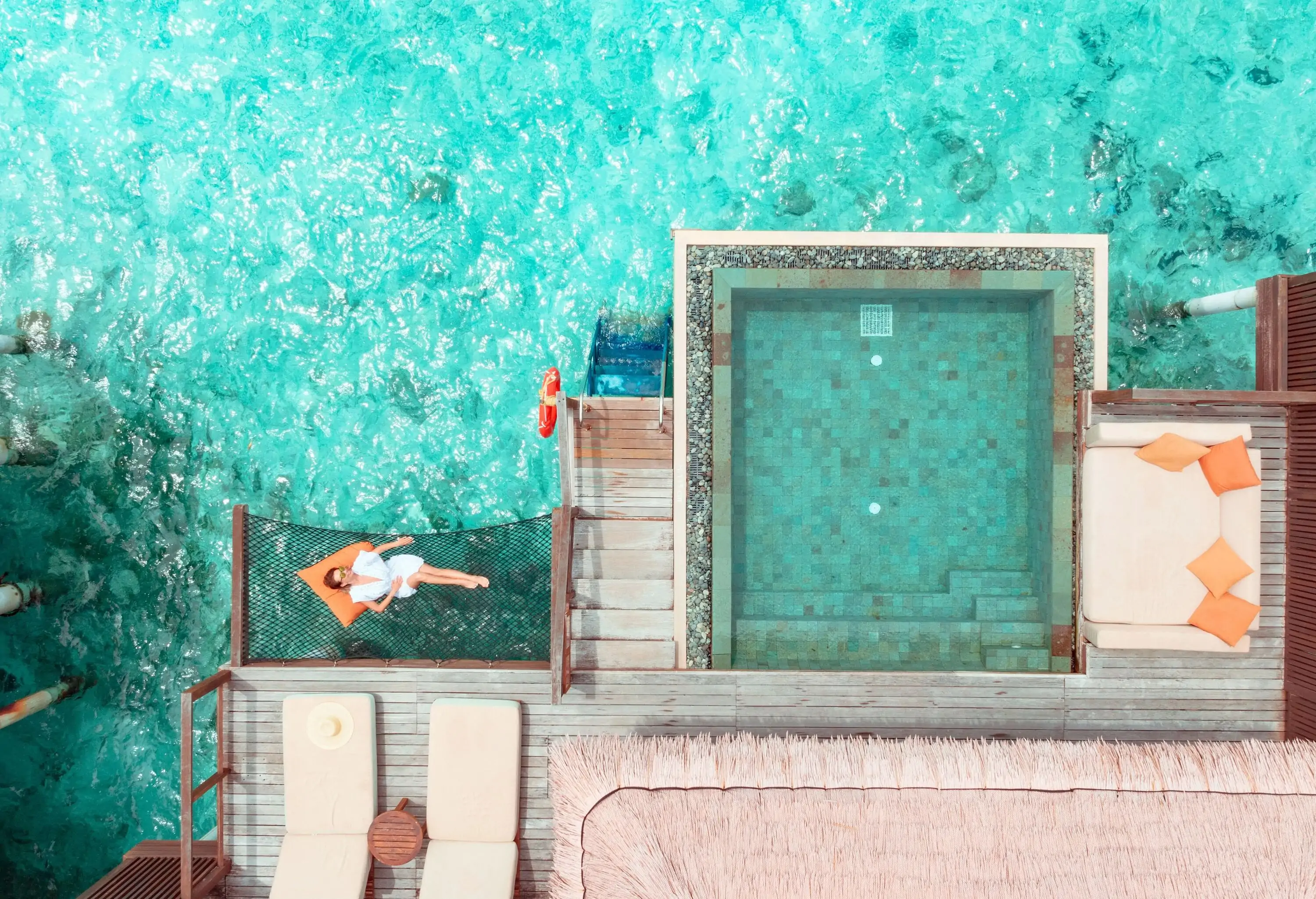 Woman lying on hammock over ocean in Maldives