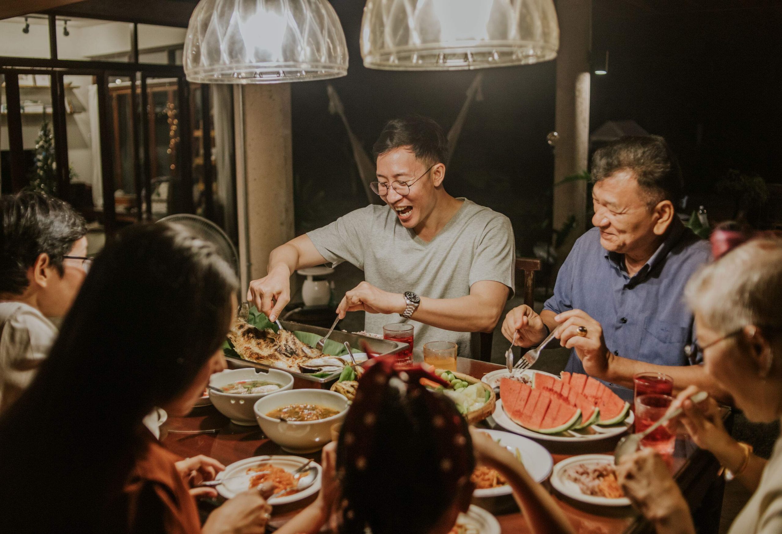 A family happily dining around a table full of food.