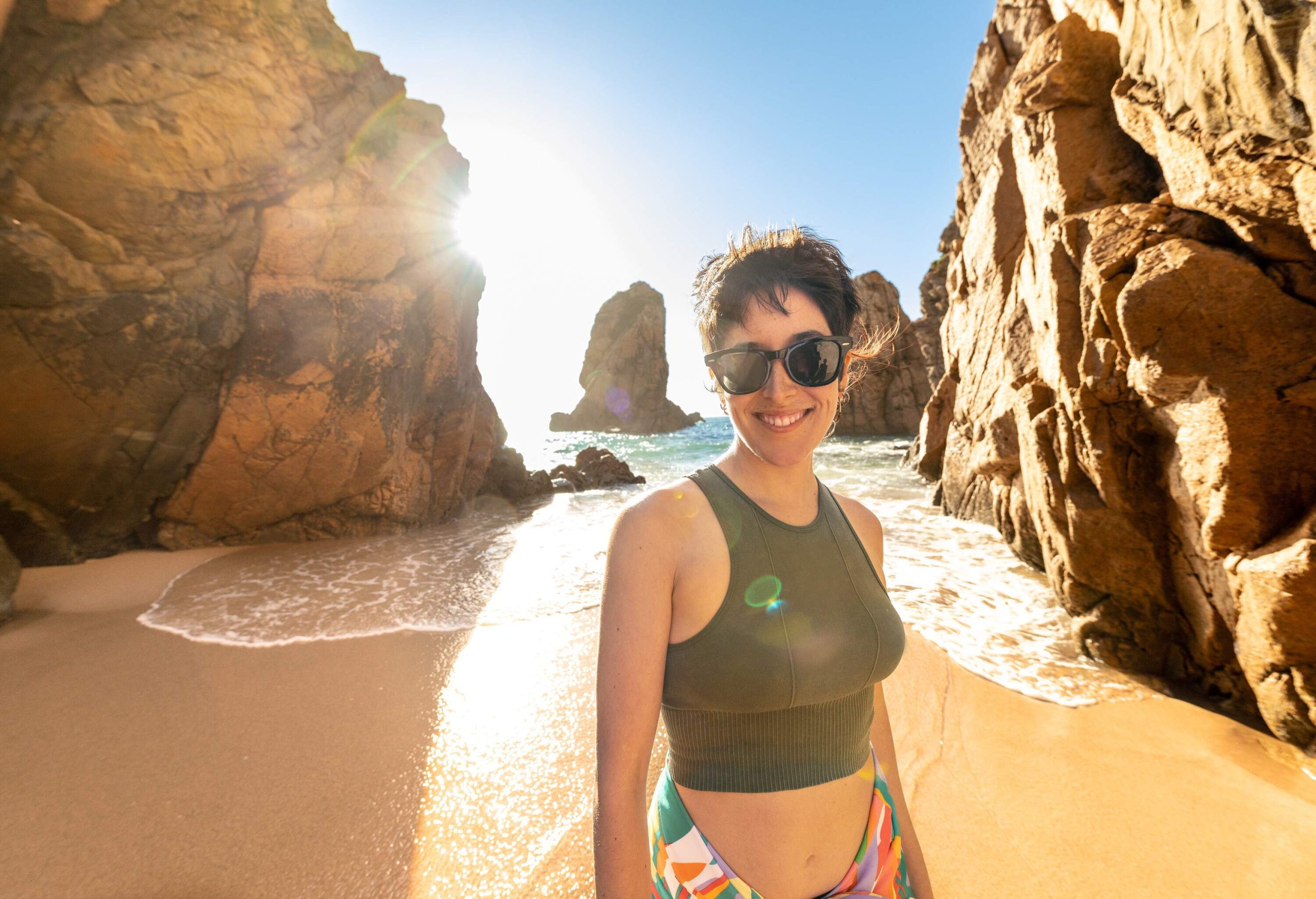 woman with sunglasses on the beach at sunset, portuguese beach paradise Praia da Adraga, short hair woman smiling