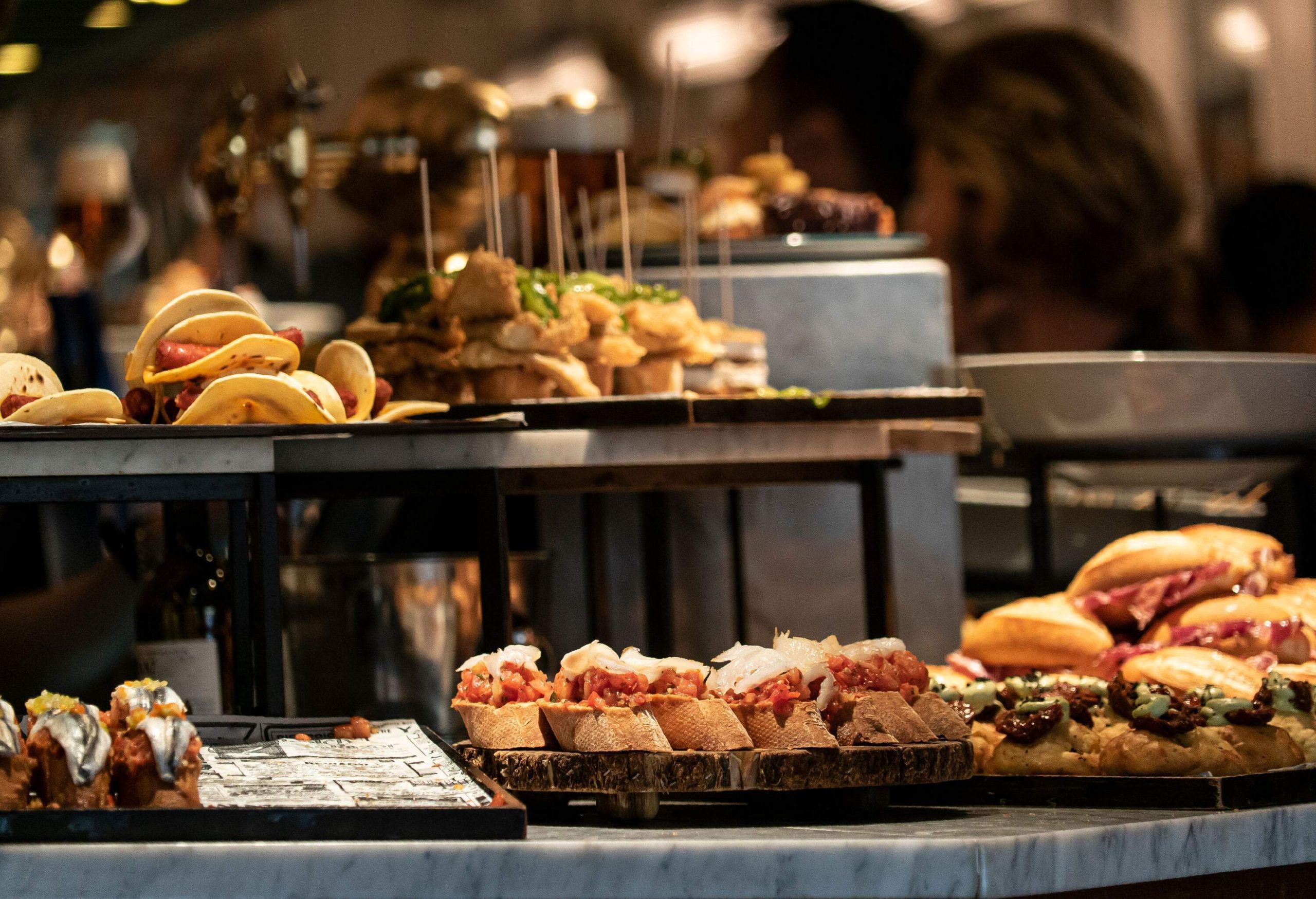 Tapas and pintxos serve on a table buffet at a bar.