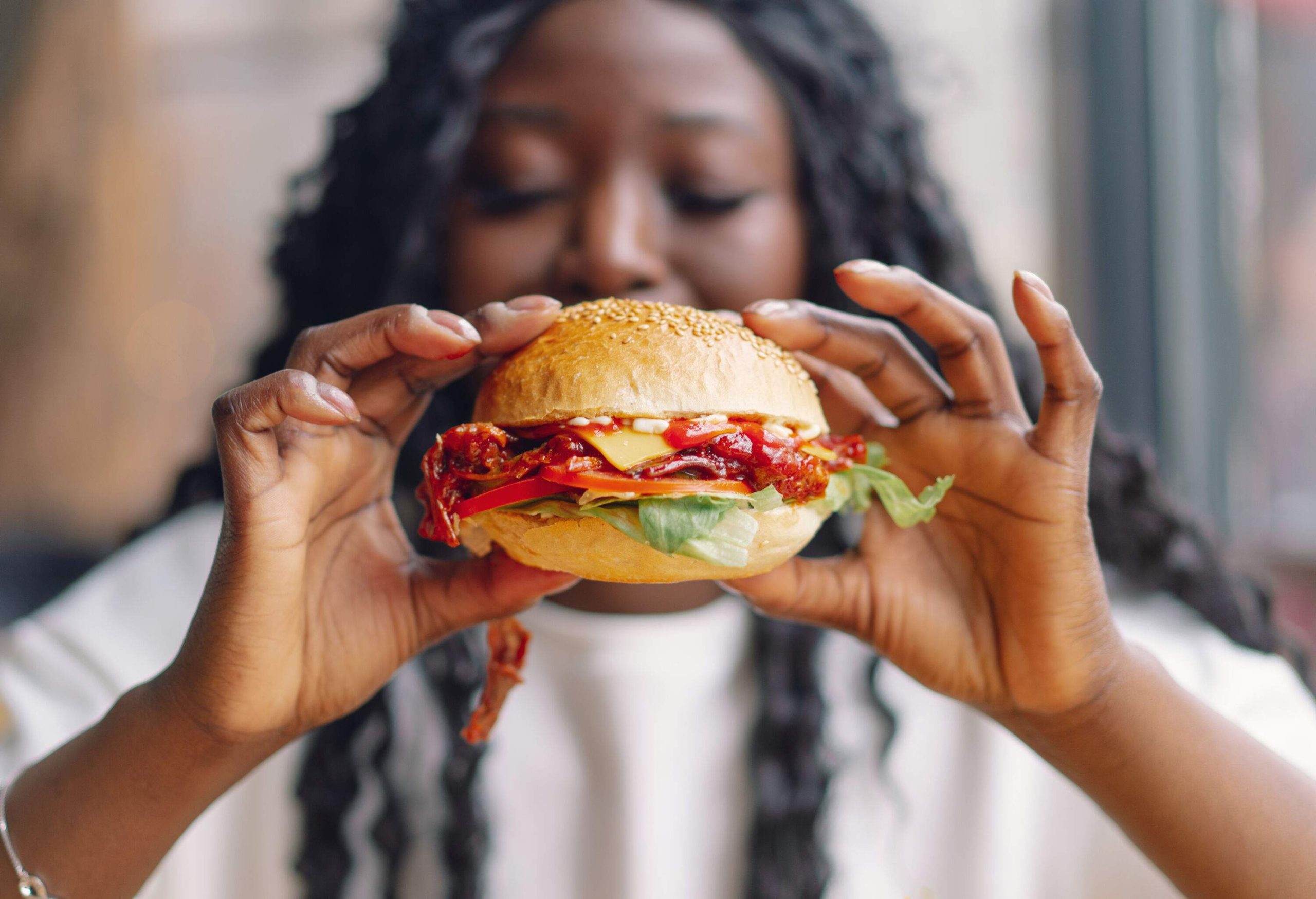 A woman shows her scrumptious burger.