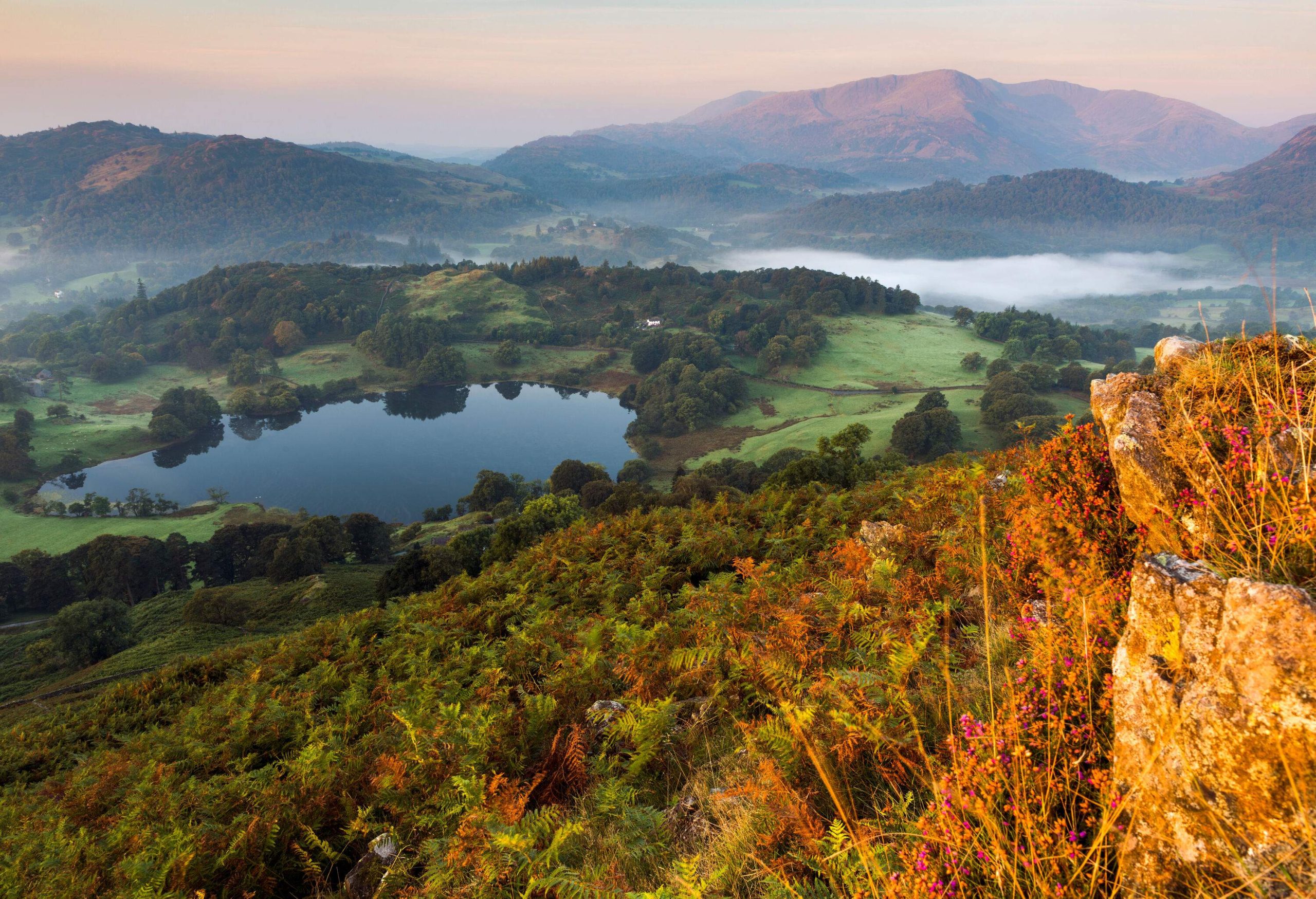 Sunlight on a small mountain lake surrounded by autumn trees.