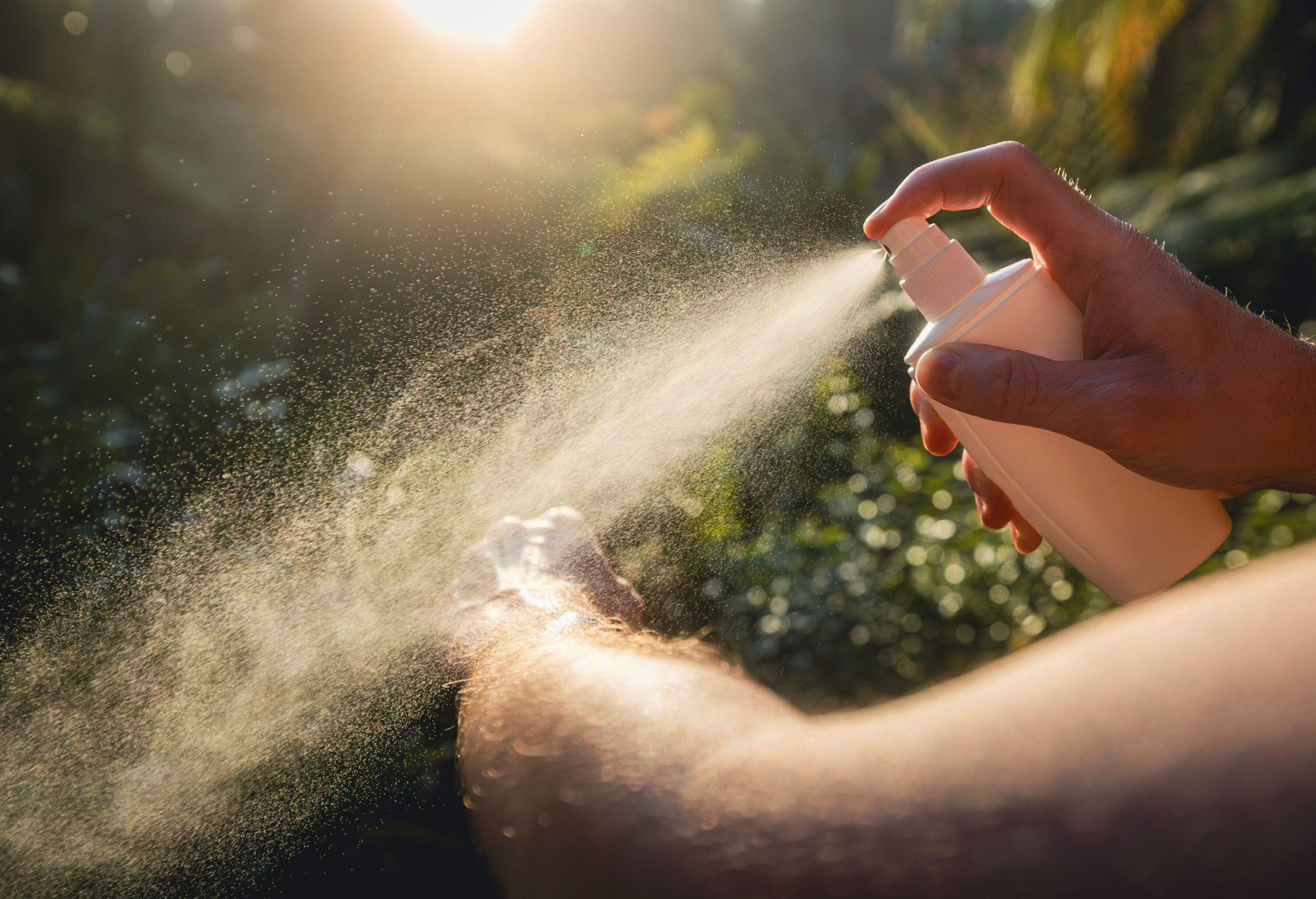 Man while applying insect repellent on his hand. Prevention against mosquito bite in tropical destination.