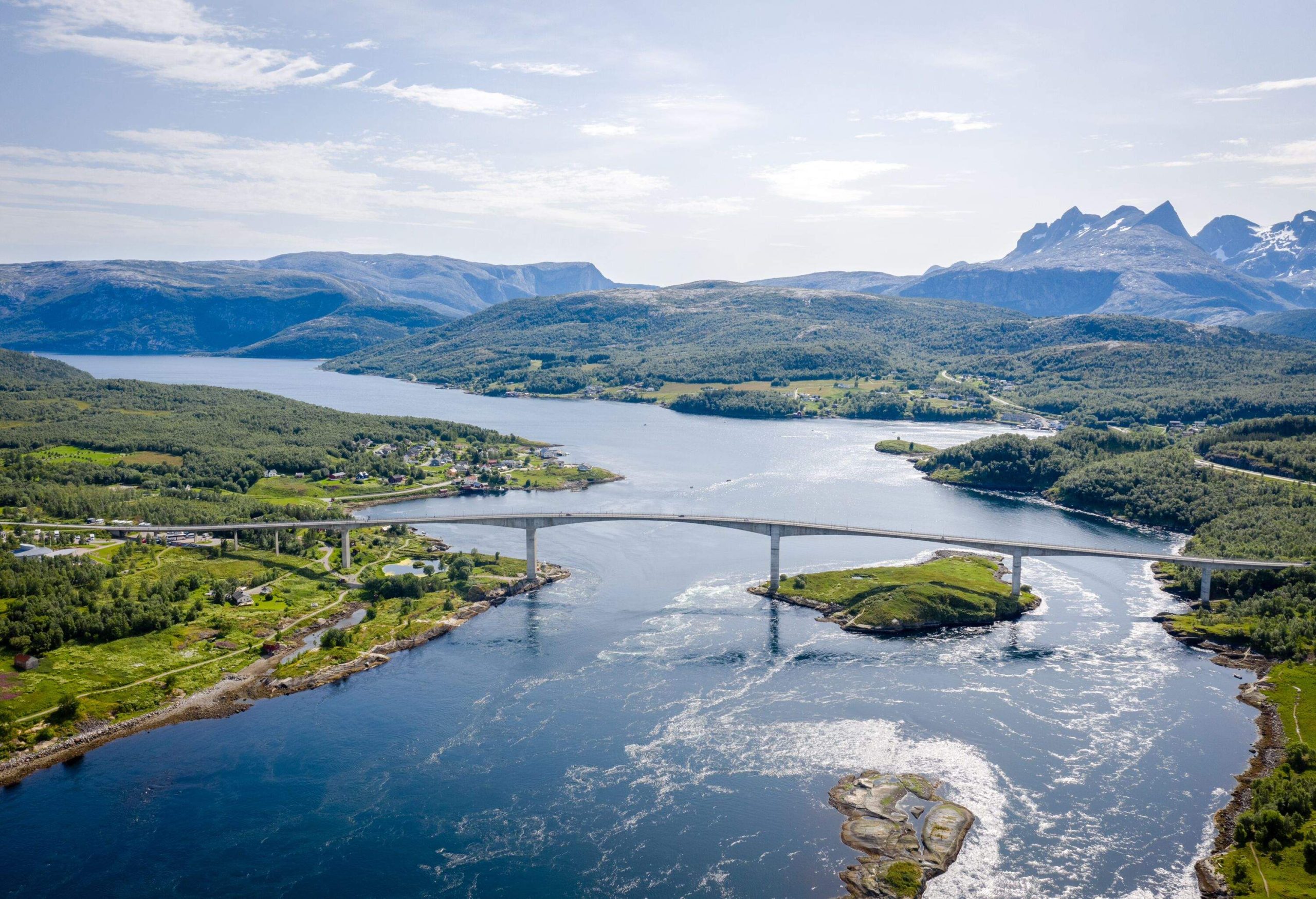 Panoramic view of the Saltstraumen bridge connecting two captivating islands and imposing mountains on a sunny day in Bodø, Norway. The Saltstraumen bridge is a cantilever box girder bridge that crosses the Saltstraumen strait. The bridge was completed in 1979 and was awarded the Concrete Prize for high quality architecture. The Saltstraumen Maelstrom is the world's strongest tidal current.