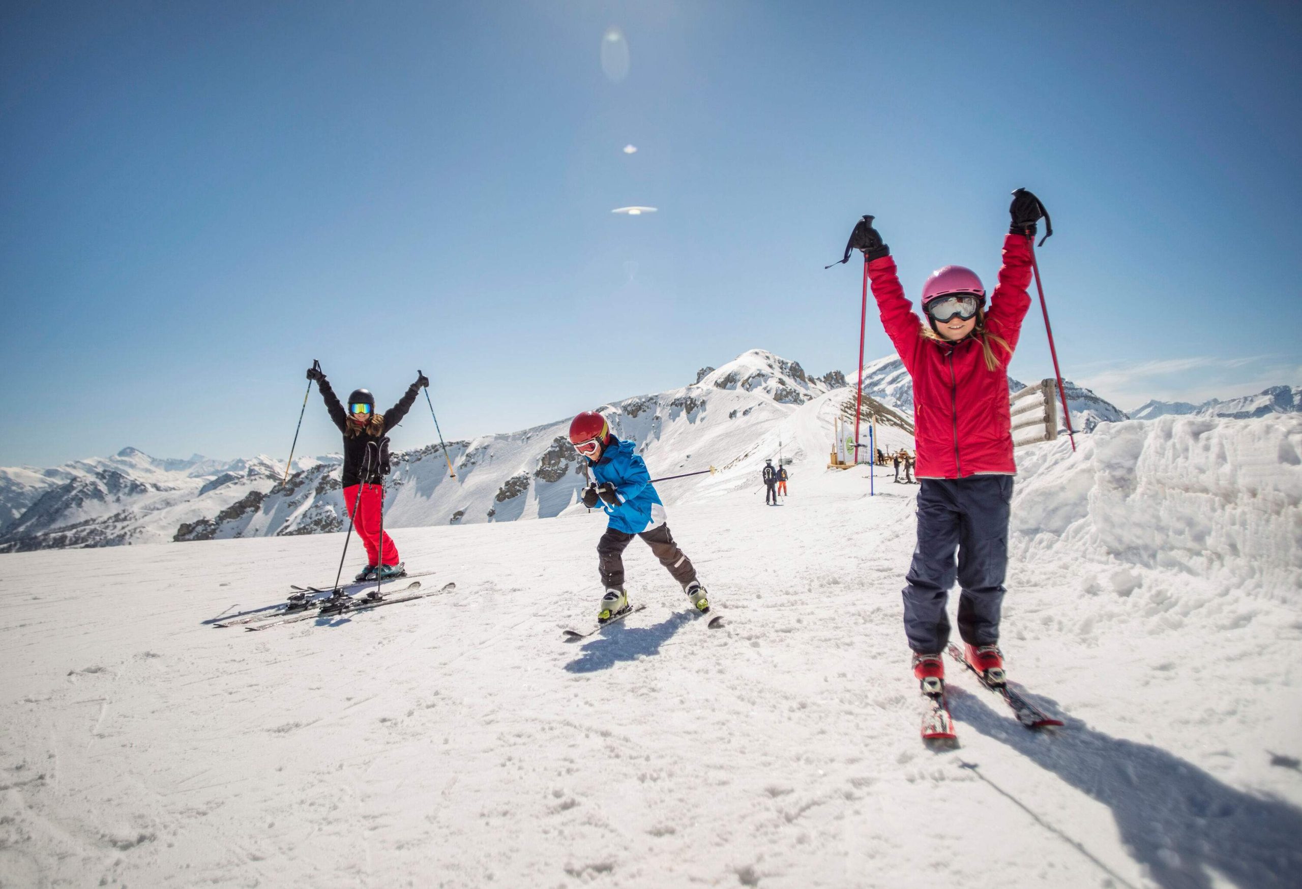 A woman and two children go skiing in the snowy mountains.