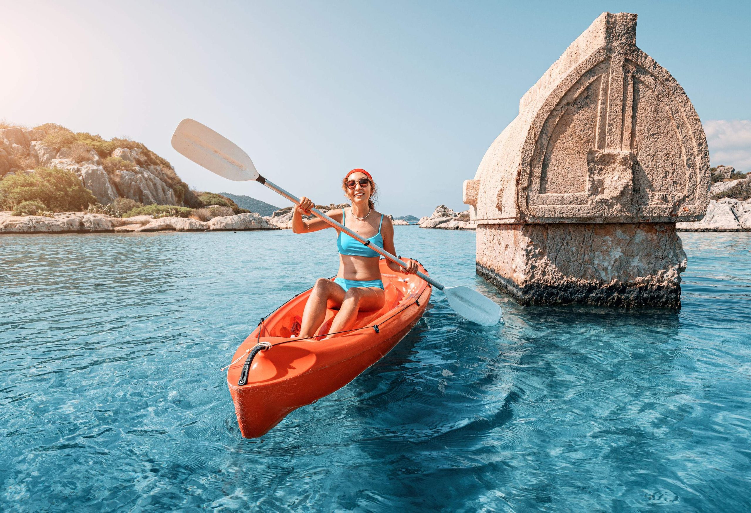 A girl on a kayak embarks on an exciting exploration of an ancient Lycian tomb, which juts out of the water amidst a flooded city.