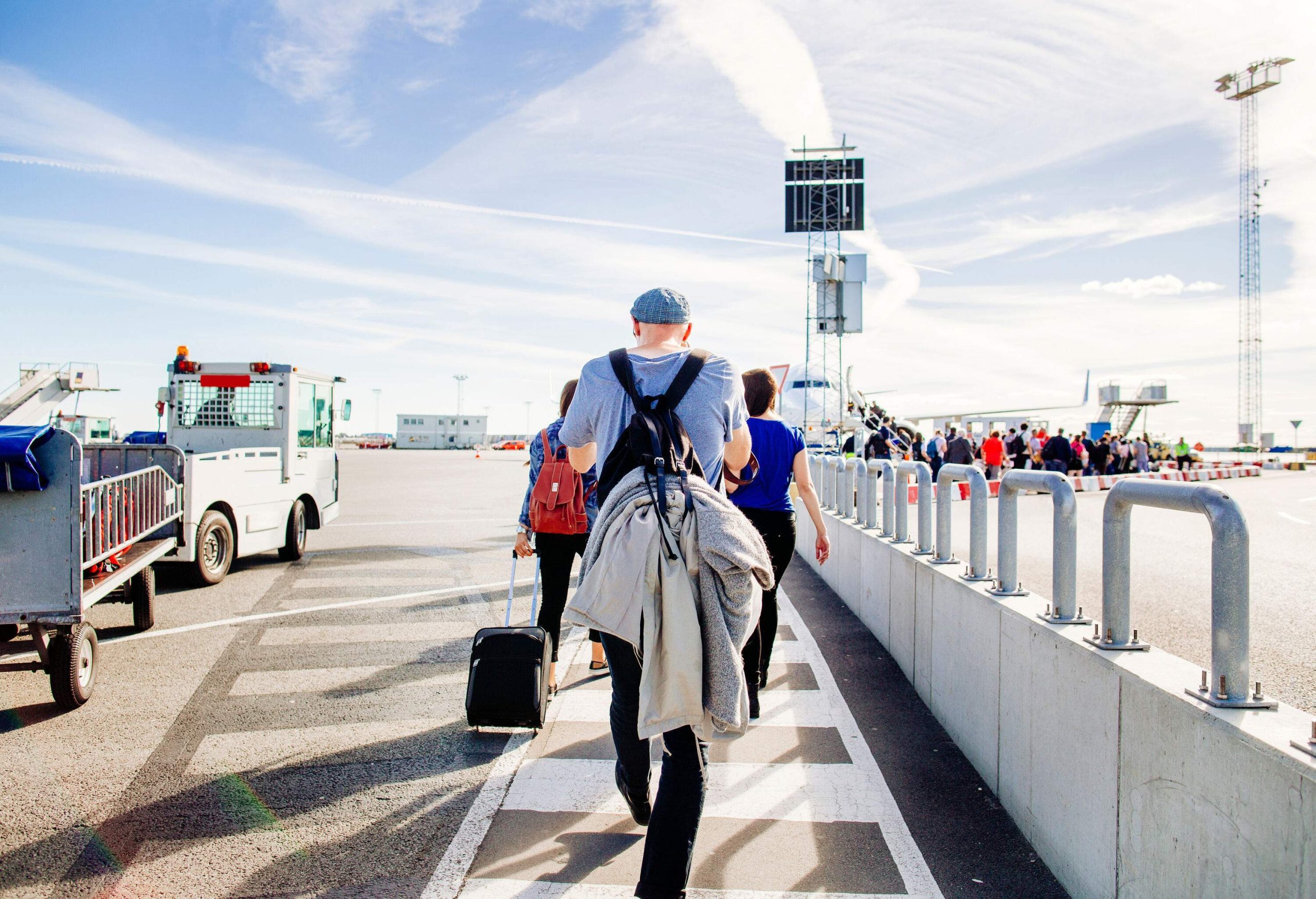 Passengers making their way down the walkway to the plane on the tarmac.