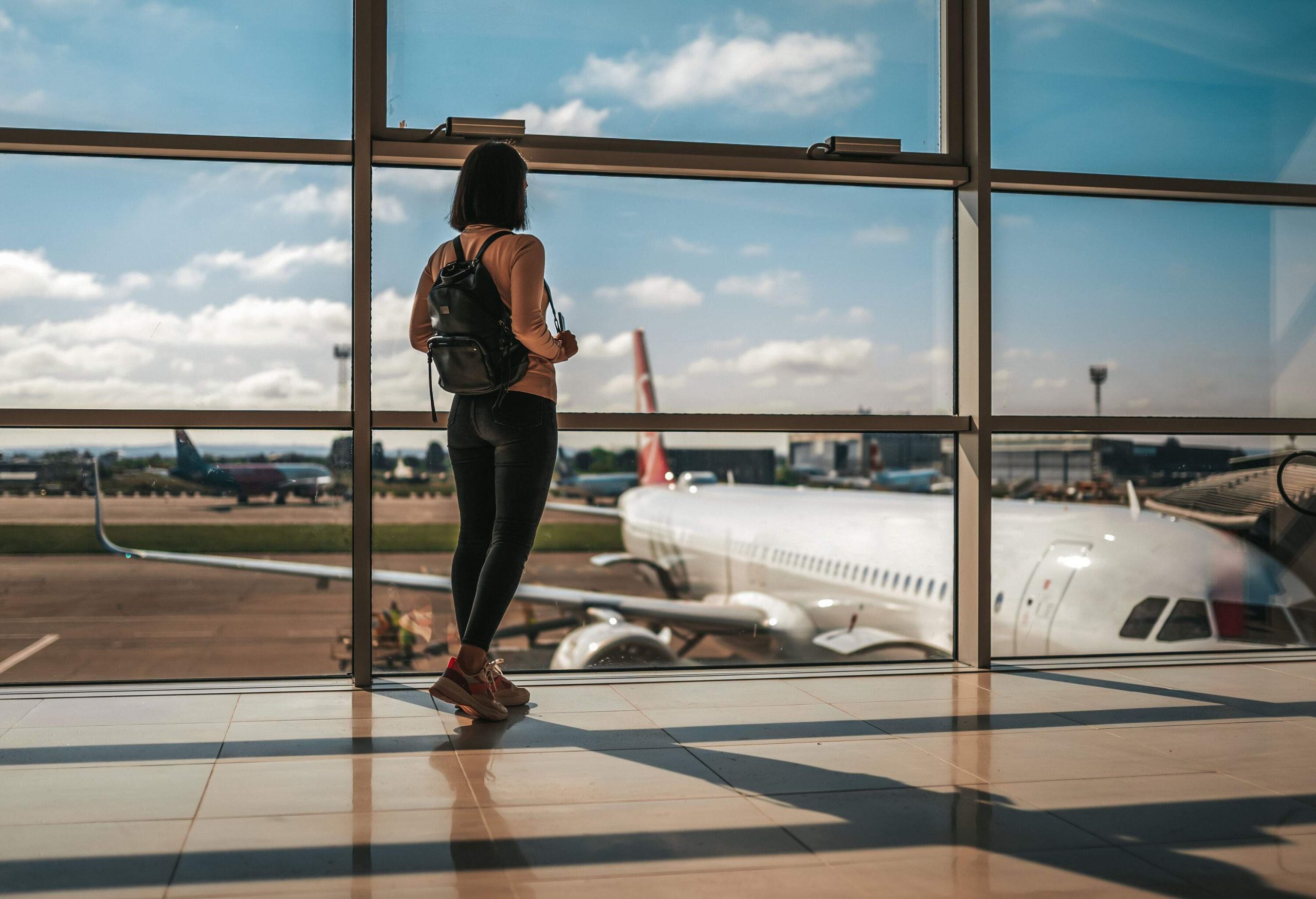 Photo of happy traveler waiting for the flight in airport, departure terminal, immigration concept