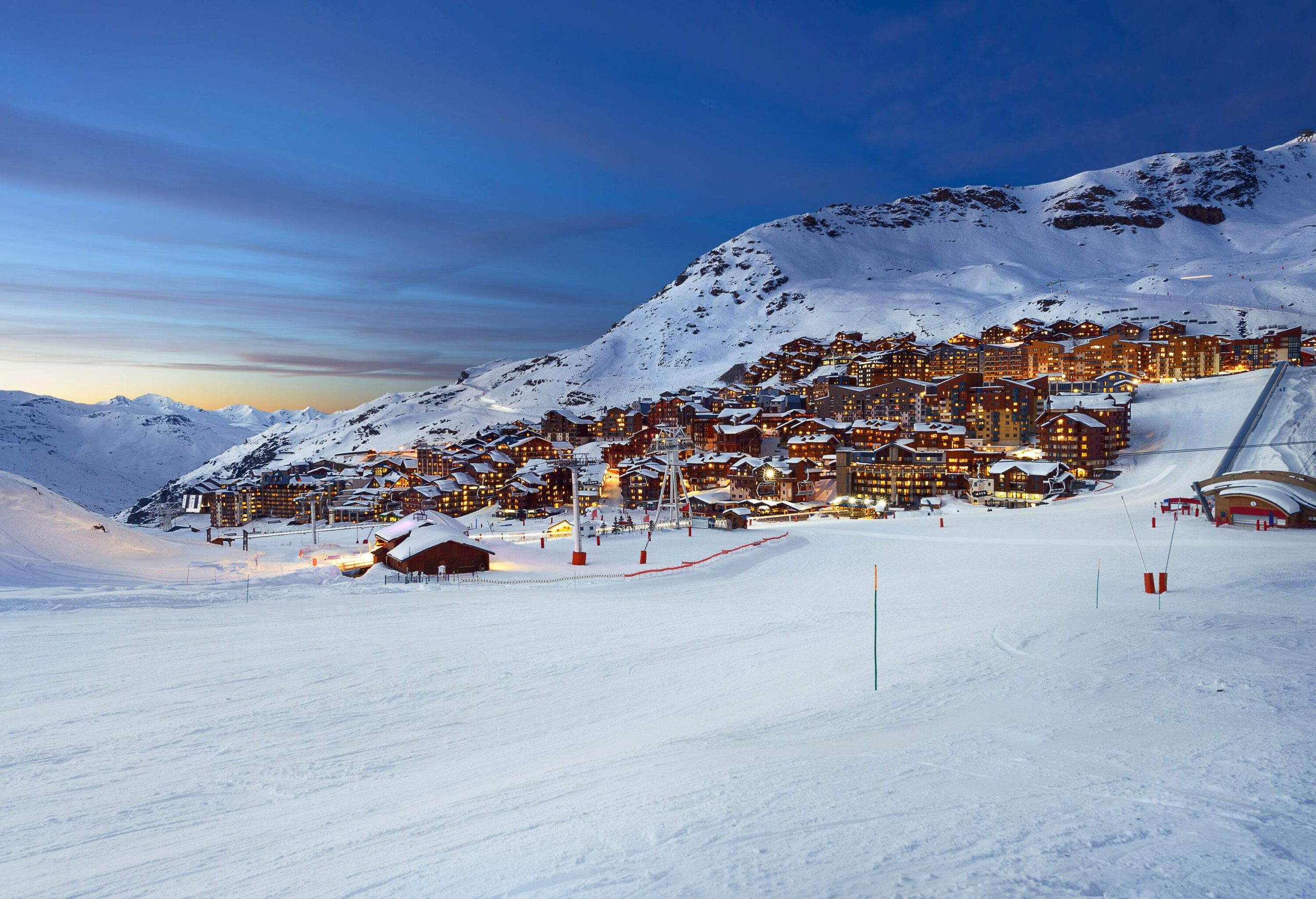 Magnificent chalets glowing at night near the snow-capped Alps.