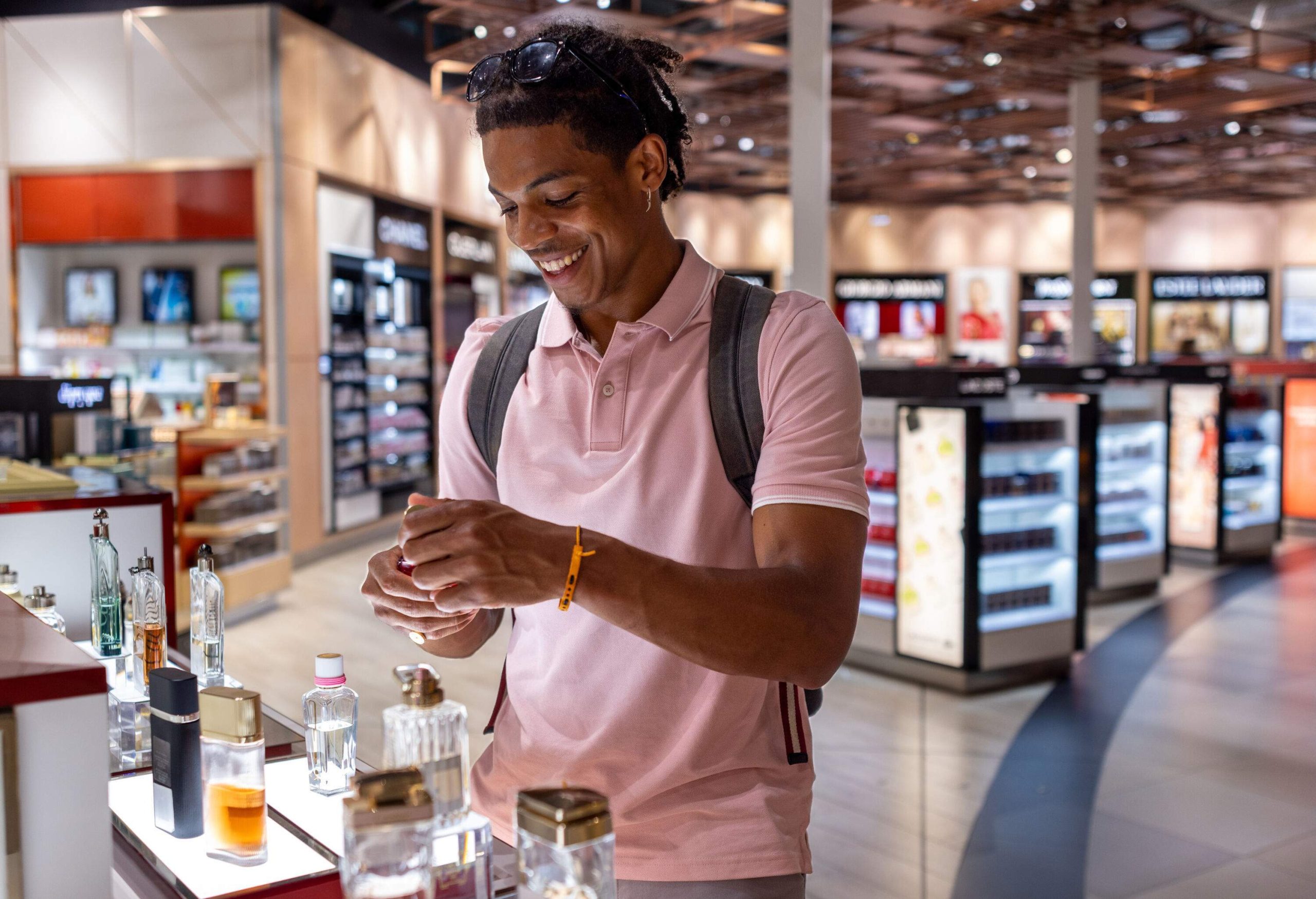 a man looking at perfumes in the dutyfree section in an airport