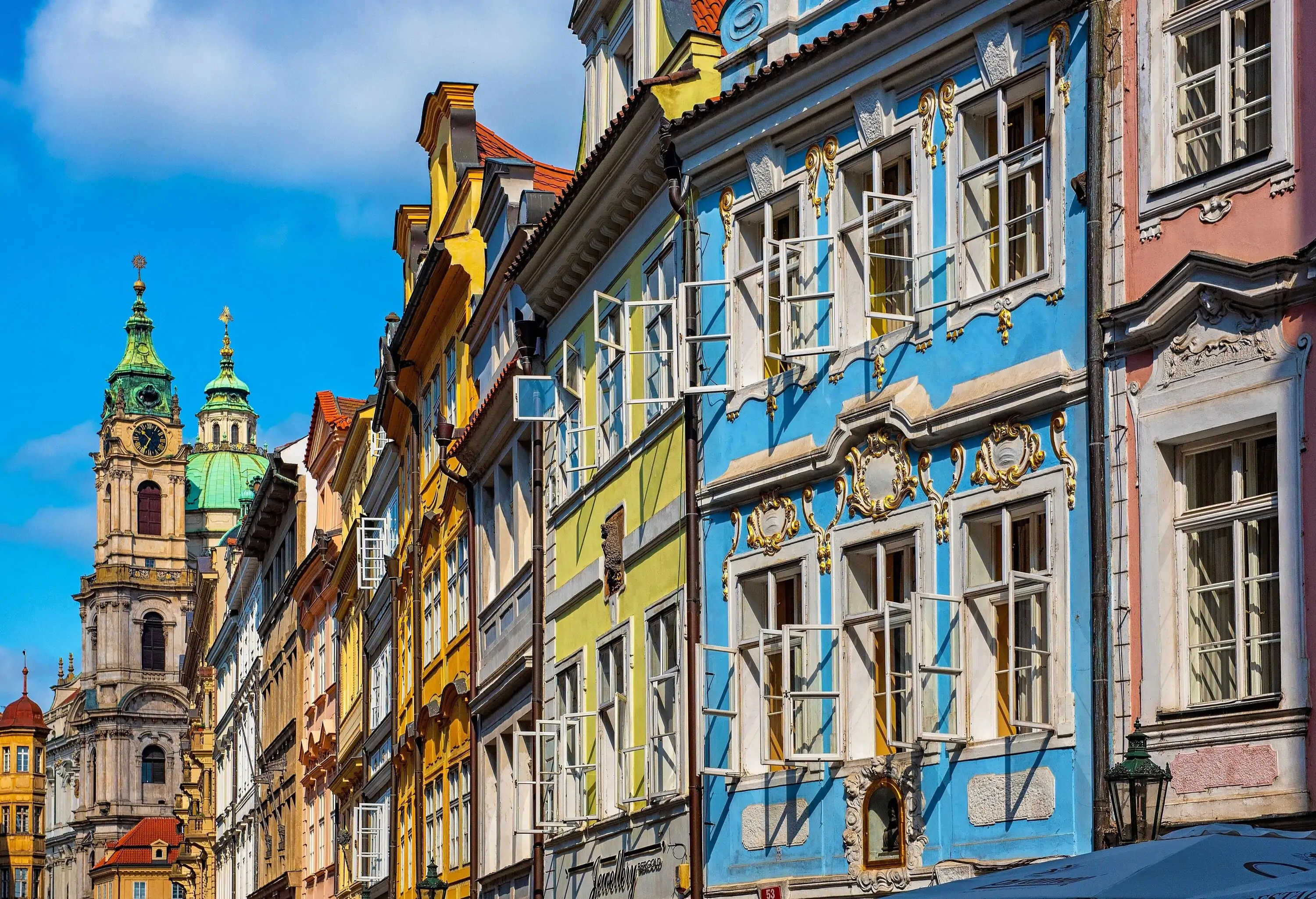 Old town is adorned with a kaleidoscope of colourful houses, tightly packed in a charming display, while a prominent clock tower stands tall in the background.