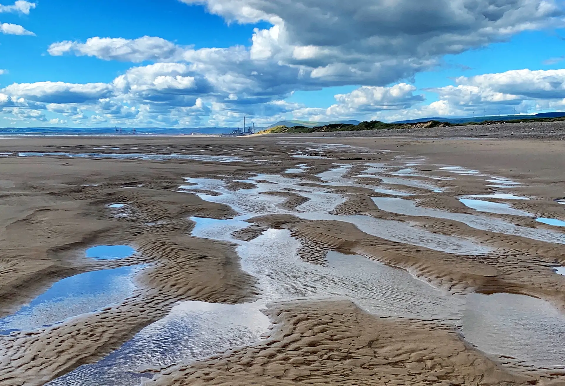 Close up of pools of sea water at low tide on Welsh beach on a sunny day