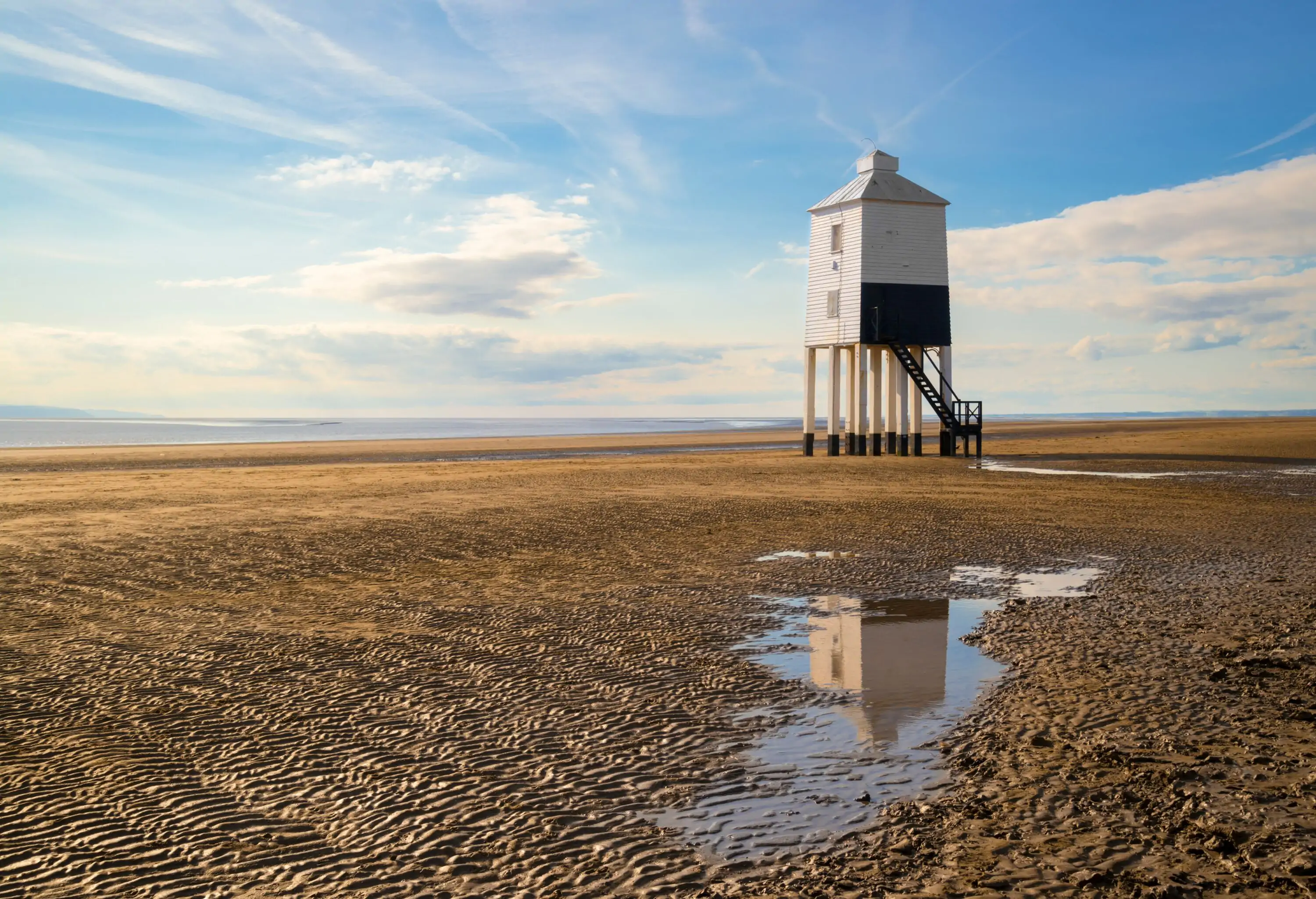 Wooden lighthouse from 1932 standing tall on stilts at a Somerset beach
