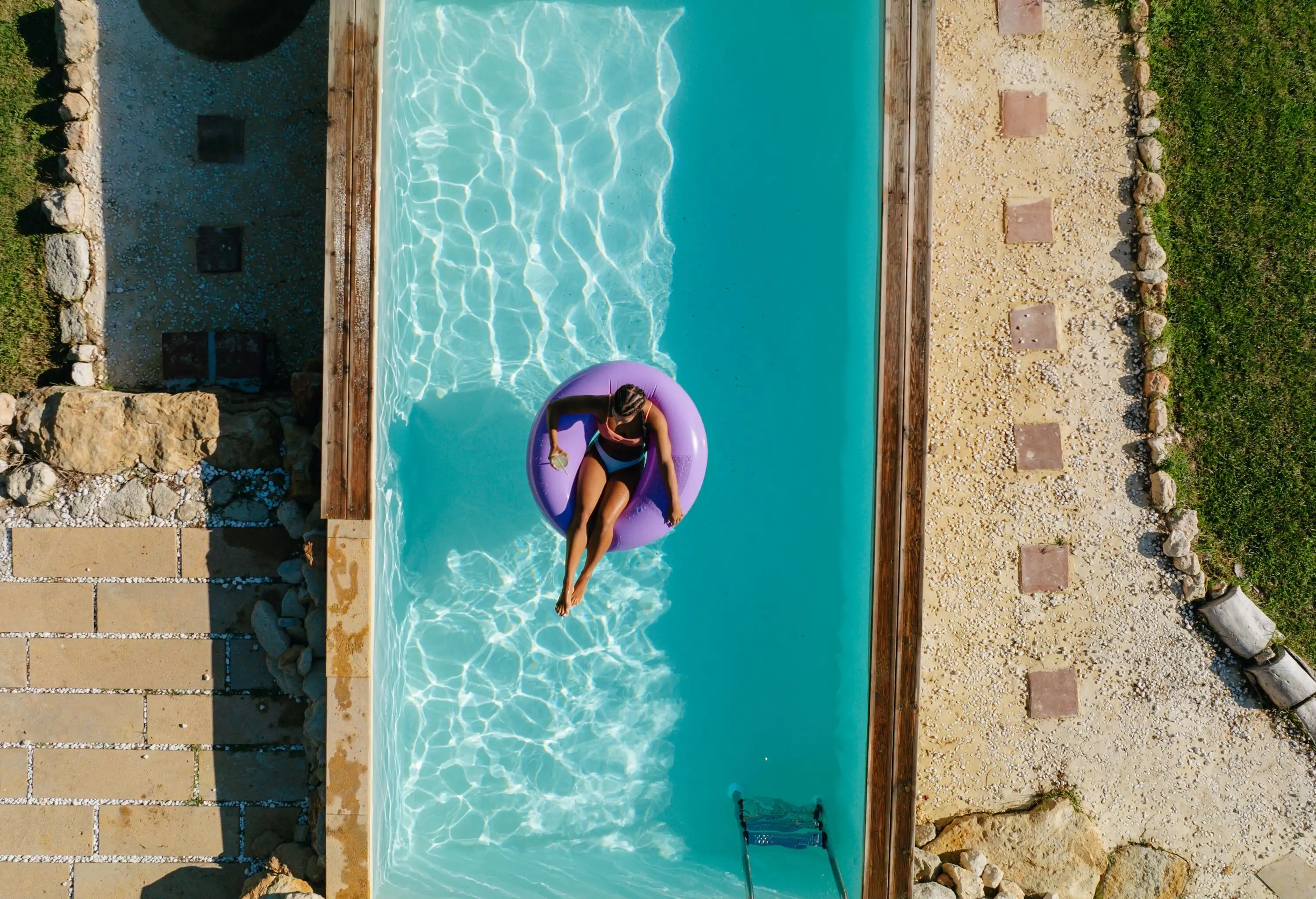 Woman lounging in a swimming pool, enjoying a moment of relaxation with calm water surrounding her.