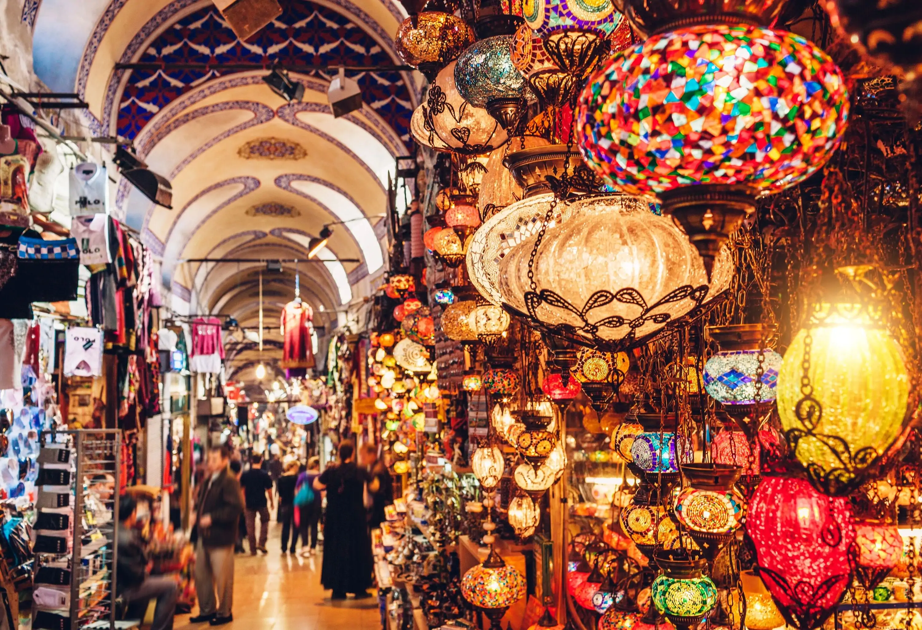 A bustling bazaar with brightly lit and colourful Moroccan pendant lights and other souvenir items.